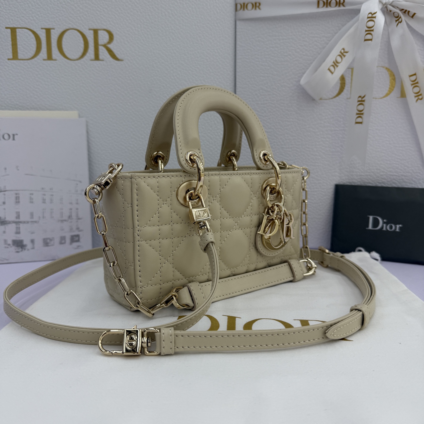 Lady D-Joy 手袋_ 编号: M0910_浅米色
这款 Lady D-Joy 超迷你手袋凸显 Lady Dior 系列的简约美学，集中体现了 Dior 对优雅和美丽的深刻洞见。采用浅米色羊皮革精心制作，饰以藤格纹缉面线，点缀以浅金色饰面金属 D.I.O.R. 吊饰提升格调，时髦典雅的设计经久不衰。搭配可拆卸的链条肩带和可调节、可拆卸的皮革肩带，可手提、肩背或斜挎，是日常或晚装造型的理想之选。
主体：羊皮革
里料：羊皮革
D.I.O.R. 吊饰
可拆卸链条肩带
可调节、可拆卸的皮革肩带
编号: S0910
意大利制造
尺寸：16 x 9 x 5 厘米（长 x 高 x 宽）
可收纳 1 部手机、1 个卡夹和唇膏
肩带长度：92 - 108 厘米
肩带顶端至手袋顶端长度：44 - 51 厘米
链条长度：46 厘米
链条顶端至手袋顶端长度：20 厘米
顶部手柄长度：18.5 厘米
顶部手柄顶端至手袋顶端长度：5.5 厘米
重量：400 克
尺寸和重量详情可能因产品材质而有所不同