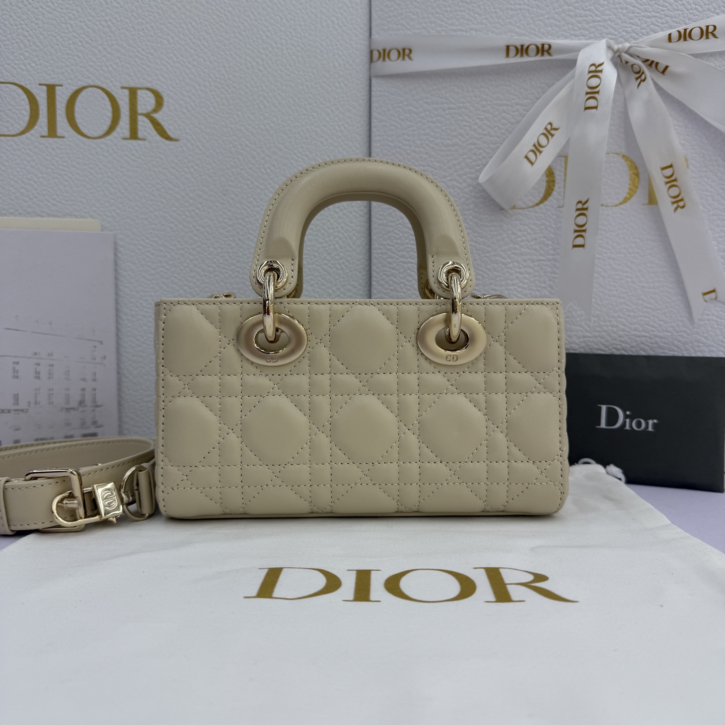 Lady D-Joy 手袋_ 款号：M0636_浅米色
这款 Lady D-Joy 手袋是二零二五秋冬成衣系列新品，凸显 Lady Dior 系列经典的简约美学，集中体现了 Dior 对典雅和美丽的深刻洞见。采用浅米色羊皮革精心制作，饰以藤格纹缉面线，时髦典雅的设计经久不衰。搭配浅金色饰面金属 D.I.O.R 吊饰提升格调，为精美的轮廓增添一分灵动。迷你款式，搭配可拆卸的链条肩带和可调节、可拆卸的皮革肩带，可手提、肩背或斜挎，是日常造型的理想之选。
主体：羊皮革里料:羊皮革可拆卸链条肩带可调节、可拆卸的皮革肩带
内部插袋
内含防尘袋
意大利制造
款号：M0636
尺寸：19&times;10.5&times;5.5厘米（长&times;高&times;宽）
可收纳1部手机、1个卡夹和唇膏
肩带长度：108-118.5 厘米
肩带顶端至手袋顶端长度：51.5-56.5 厘米
链条长度：54.5厘米
链条顶端至手袋顶端长度：24厘米
重量：660克
尺寸和重量详情可能因产品材质有所不同