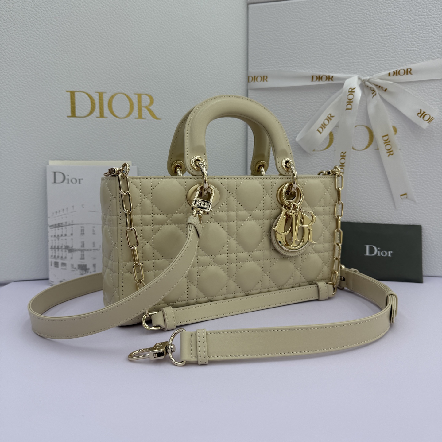 Lady D-Joy 手袋_ 编号：0540_浅米色
这款 Lady D-Joy 手袋凸显 Lady Dior 系列的简约美学，集中体现了 Dior 对典雅和美丽的深刻洞见。采用浅米色羊皮革精心制作，以经典的藤格纹缉面线打造醒目的绗缝细节，精良的缝制工艺显露无遗。同色调金属 D.I.O.R. 吊饰彰显优雅气质。小号款式，搭配可拆卸的链条肩带和可调节、可拆卸的皮革肩带，可手提、肩背或斜挎，是日常造型的理想之选。
可拆卸链条肩带
可拆卸、可调节的皮革肩带
编号：0540
尺寸：26&times;13.5&times;5cm
可收纳一部 iPhone和其他配饰