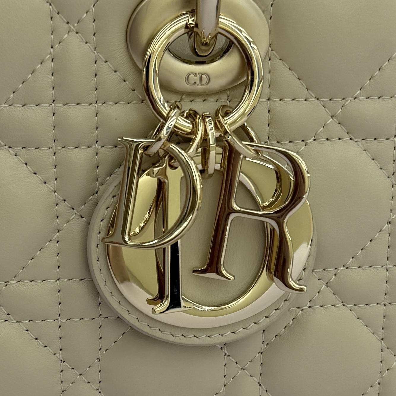 Lady D-Joy 手袋_ 编号：0540_浅米色
这款 Lady D-Joy 手袋凸显 Lady Dior 系列的简约美学，集中体现了 Dior 对典雅和美丽的深刻洞见。采用浅米色羊皮革精心制作，以经典的藤格纹缉面线打造醒目的绗缝细节，精良的缝制工艺显露无遗。同色调金属 D.I.O.R. 吊饰彰显优雅气质。小号款式，搭配可拆卸的链条肩带和可调节、可拆卸的皮革肩带，可手提、肩背或斜挎，是日常造型的理想之选。
可拆卸链条肩带
可拆卸、可调节的皮革肩带
编号：0540
尺寸：26&times;13.5&times;5cm
可收纳一部 iPhone和其他配饰