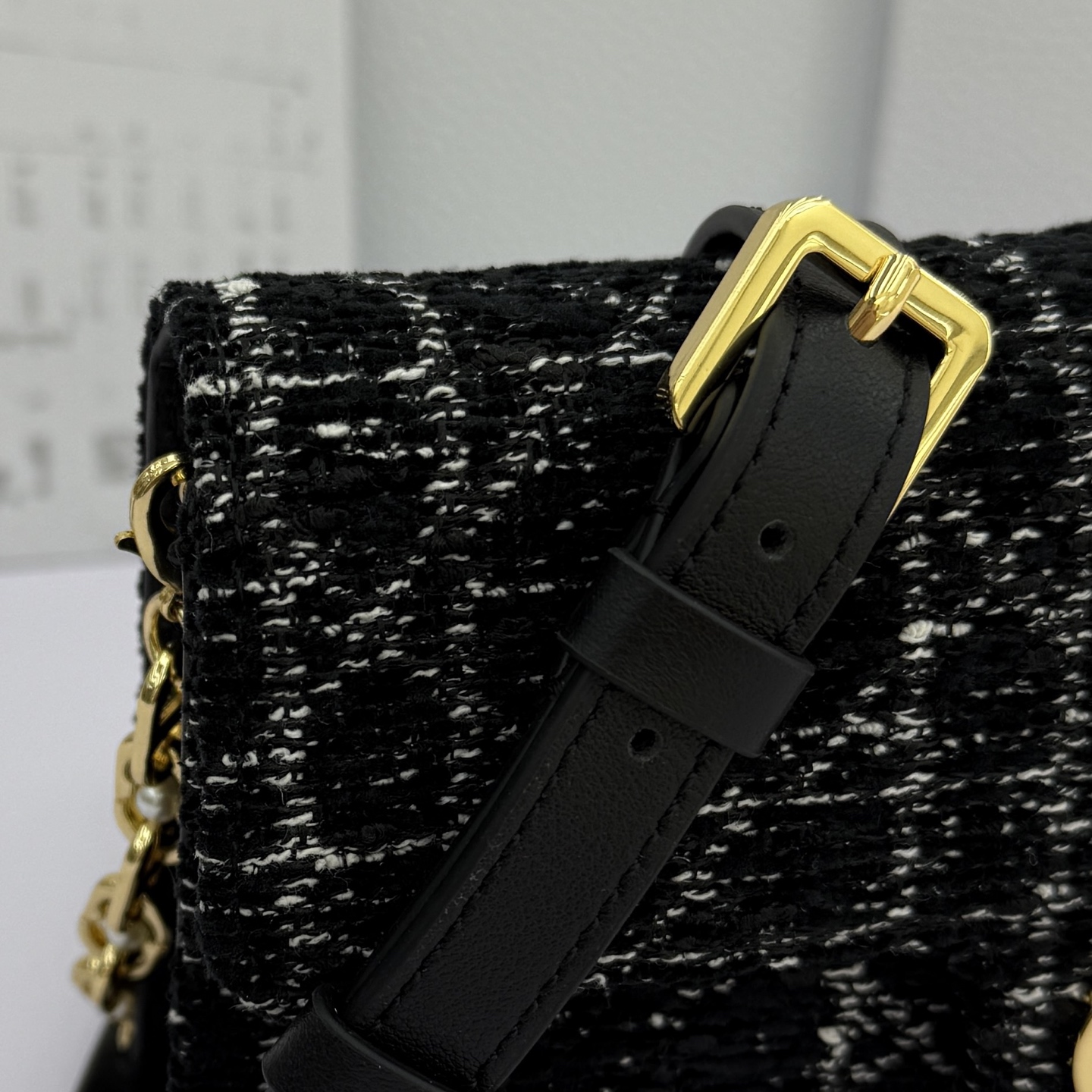 Dior Jolie 迷你鏈條手袋_編號:S3117_黑布
这款 Dior Jolie 迷你链条手袋是二零二五秋冬成衣系列新品，兼具优雅气质与实用功能。采用黑布羊皮革精心制作，搭配黑色藤格纹粗花呢等材质精心制作，翻盖饰以点缀白色树脂珠饰的复古金色饰面金属CD 标志。内设一个隔层，可收纳各种用品。搭配可调节、可拆卸CD链环肩带，穿插点缀以白色树脂珠饰，饰以皮革带，可搭配日常造型或晚装舒适手提、肩背或斜挎。 
主體:羊皮革，黑色藤格纹粗花
里料:羊皮革，科技面料 正面CD 扣环饰以白色树脂珠饰翻盖开合内部插袋6 个卡槽 饰以树脂珠饰和皮革带的可调节、可拆卸链条肩带内含防尘袋意大利制造 
尺寸：21cm&times;11.5cm&times;4.5cm 
编号：S3117