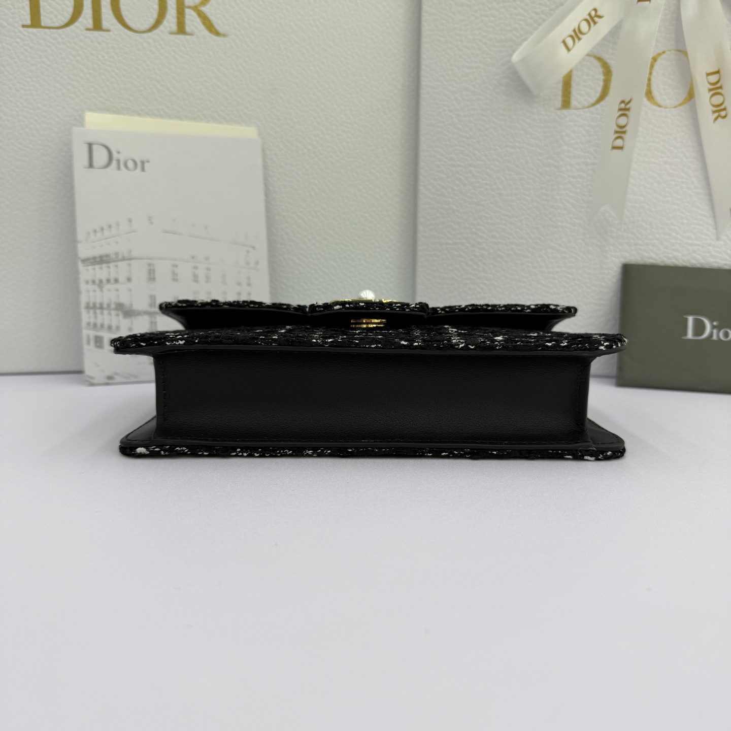 Dior Jolie 迷你鏈條手袋_編號:S3117_黑布
这款 Dior Jolie 迷你链条手袋是二零二五秋冬成衣系列新品，兼具优雅气质与实用功能。采用黑布羊皮革精心制作，搭配黑色藤格纹粗花呢等材质精心制作，翻盖饰以点缀白色树脂珠饰的复古金色饰面金属CD 标志。内设一个隔层，可收纳各种用品。搭配可调节、可拆卸CD链环肩带，穿插点缀以白色树脂珠饰，饰以皮革带，可搭配日常造型或晚装舒适手提、肩背或斜挎。 
主體:羊皮革，黑色藤格纹粗花
里料:羊皮革，科技面料 正面CD 扣环饰以白色树脂珠饰翻盖开合内部插袋6 个卡槽 饰以树脂珠饰和皮革带的可调节、可拆卸链条肩带内含防尘袋意大利制造 
尺寸：21cm&times;11.5cm&times;4.5cm 
编号：S3117