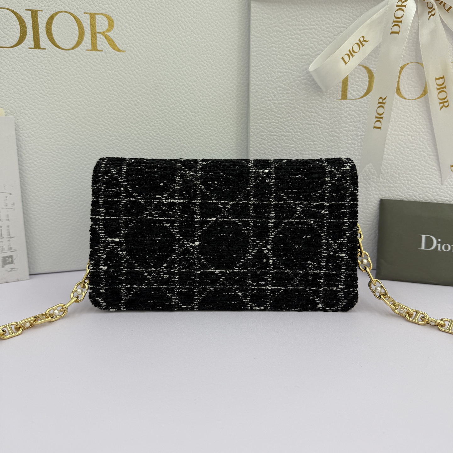 Dior Jolie 迷你鏈條手袋_編號:S3117_黑布
这款 Dior Jolie 迷你链条手袋是二零二五秋冬成衣系列新品，兼具优雅气质与实用功能。采用黑布羊皮革精心制作，搭配黑色藤格纹粗花呢等材质精心制作，翻盖饰以点缀白色树脂珠饰的复古金色饰面金属CD 标志。内设一个隔层，可收纳各种用品。搭配可调节、可拆卸CD链环肩带，穿插点缀以白色树脂珠饰，饰以皮革带，可搭配日常造型或晚装舒适手提、肩背或斜挎。 
主體:羊皮革，黑色藤格纹粗花
里料:羊皮革，科技面料 正面CD 扣环饰以白色树脂珠饰翻盖开合内部插袋6 个卡槽 饰以树脂珠饰和皮革带的可调节、可拆卸链条肩带内含防尘袋意大利制造 
尺寸：21cm&times;11.5cm&times;4.5cm 
编号：S3117
