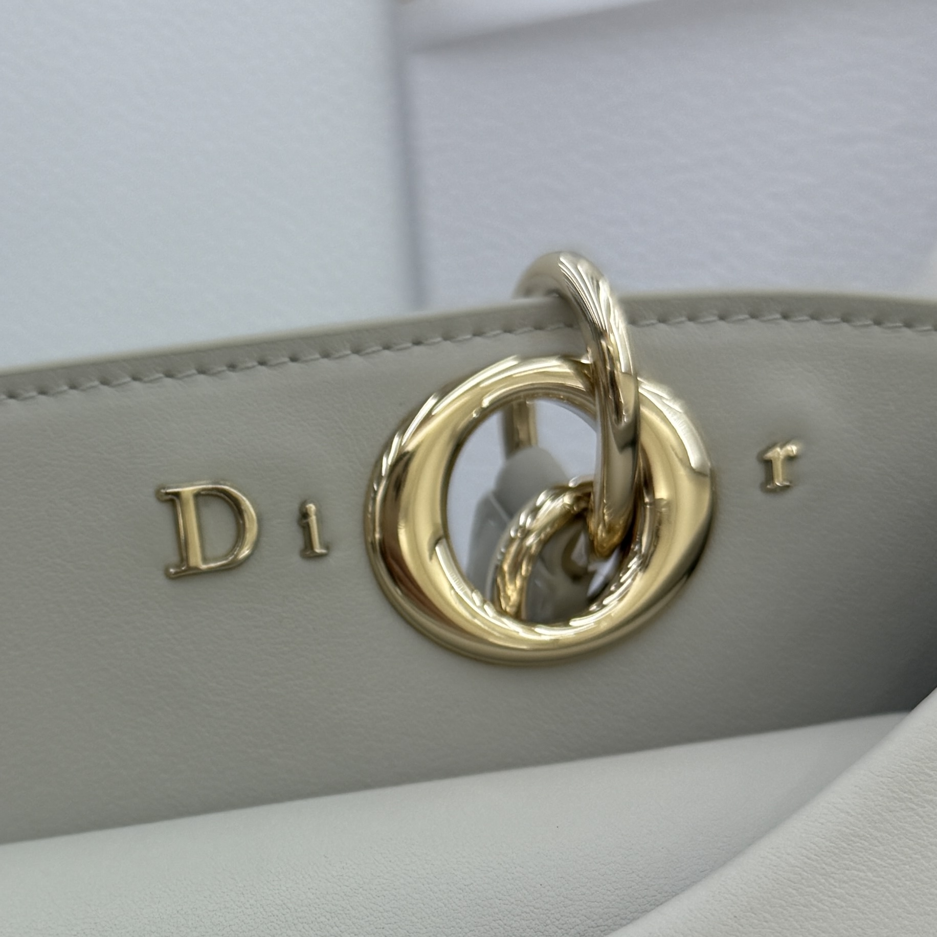 Dior 2026蝴蝶结手提包_编号7038_云雾灰金扣
🎀 Dior 2026 春夏新品#蝴蝶结手提包「云雾灰色」
新设计的轮廓与造型，配色 丰富，适配多人！在夸张与优雅之间恰到好处！它的设计灵感源于迪奥先生设计的 Cigale礼服~立体的梯形包身+单手柄，造型自带优雅大气的腔调。包包的外观比较低调，几乎没有什么明显的大Logo。离近点再看，才发现原来Anderson把Dior字母Logo和包包提手的圆孔融合到了一起。
包包既有辨识度，也完全不是张扬挂的，整体散发着那种不动声色的高级感！值得一提的是，这款包还搭配了一条皮质长肩带。尤其出门旅行的时候就可以换上长肩带，既解放了双手，还衬得人轻松又随性~
型号：7038
尺寸：28*10*22（长*宽*高）