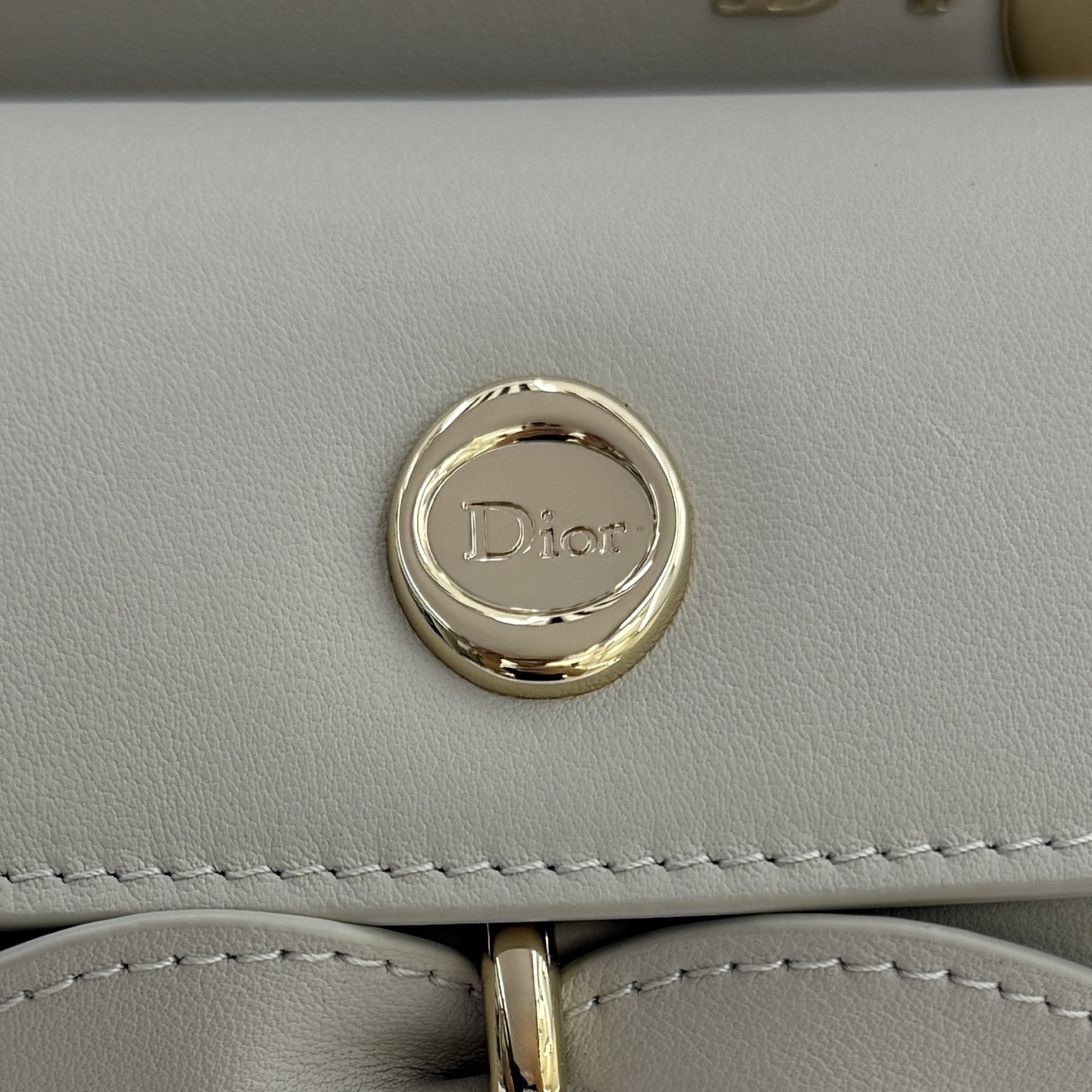 Dior 2026蝴蝶结手提包_编号7038_云雾灰金扣
🎀 Dior 2026 春夏新品#蝴蝶结手提包「云雾灰色」
新设计的轮廓与造型，配色 丰富，适配多人！在夸张与优雅之间恰到好处！它的设计灵感源于迪奥先生设计的 Cigale礼服~立体的梯形包身+单手柄，造型自带优雅大气的腔调。包包的外观比较低调，几乎没有什么明显的大Logo。离近点再看，才发现原来Anderson把Dior字母Logo和包包提手的圆孔融合到了一起。
包包既有辨识度，也完全不是张扬挂的，整体散发着那种不动声色的高级感！值得一提的是，这款包还搭配了一条皮质长肩带。尤其出门旅行的时候就可以换上长肩带，既解放了双手，还衬得人轻松又随性~
型号：7038
尺寸：28*10*22（长*宽*高）