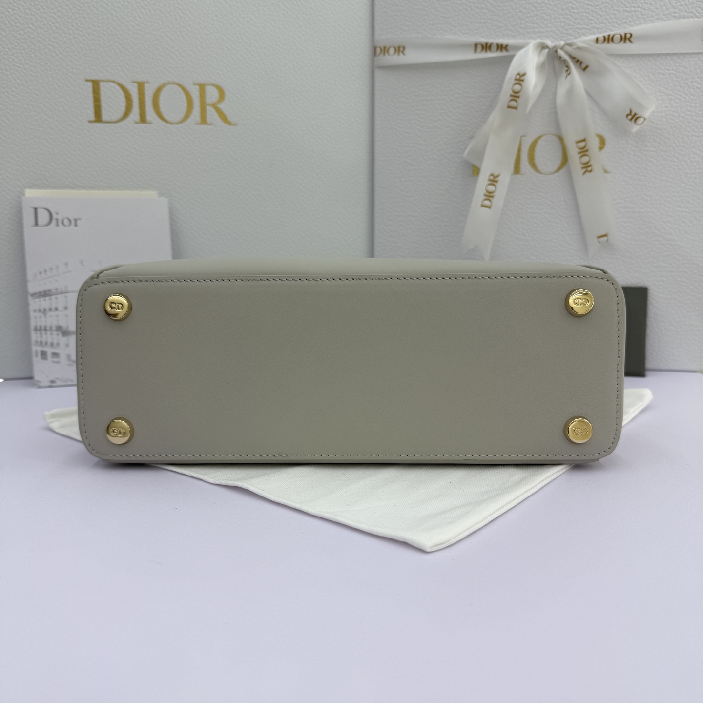 Dior 2026蝴蝶结手提包_编号7038_云雾灰金扣
🎀 Dior 2026 春夏新品#蝴蝶结手提包「云雾灰色」
新设计的轮廓与造型，配色 丰富，适配多人！在夸张与优雅之间恰到好处！它的设计灵感源于迪奥先生设计的 Cigale礼服~立体的梯形包身+单手柄，造型自带优雅大气的腔调。包包的外观比较低调，几乎没有什么明显的大Logo。离近点再看，才发现原来Anderson把Dior字母Logo和包包提手的圆孔融合到了一起。
包包既有辨识度，也完全不是张扬挂的，整体散发着那种不动声色的高级感！值得一提的是，这款包还搭配了一条皮质长肩带。尤其出门旅行的时候就可以换上长肩带，既解放了双手，还衬得人轻松又随性~
型号：7038
尺寸：28*10*22（长*宽*高）