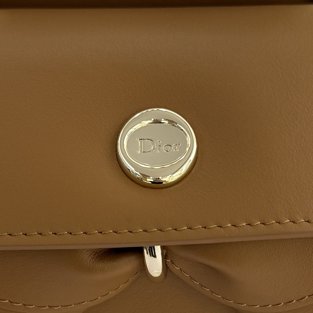 Dior 2026蝴蝶结手提包_编号7038_焦糖色金扣
🎀 Dior 2026 春夏新品#蝴蝶结手提包「焦糖色」
新设计的轮廓与造型，配色 丰富，适配多人！在夸张与优雅之间恰到好处！它的设计灵感源于迪奥先生设计的 Cigale礼服~立体的梯形包身+单手柄，造型自带优雅大气的腔调。包包的外观比较低调，几乎没有什么明显的大Logo。离近点再看，才发现原来Anderson把Dior字母Logo和包包提手的圆孔融合到了一起。
包包既有辨识度，也完全不是张扬挂的，整体散发着那种不动声色的高级感！值得一提的是，这款包还搭配了一条皮质长肩带。尤其出门旅行的时候就可以换上长肩带，既解放了双手，还衬得人轻松又随性~
型号：7038
尺寸：28*10*22（长*宽*高）