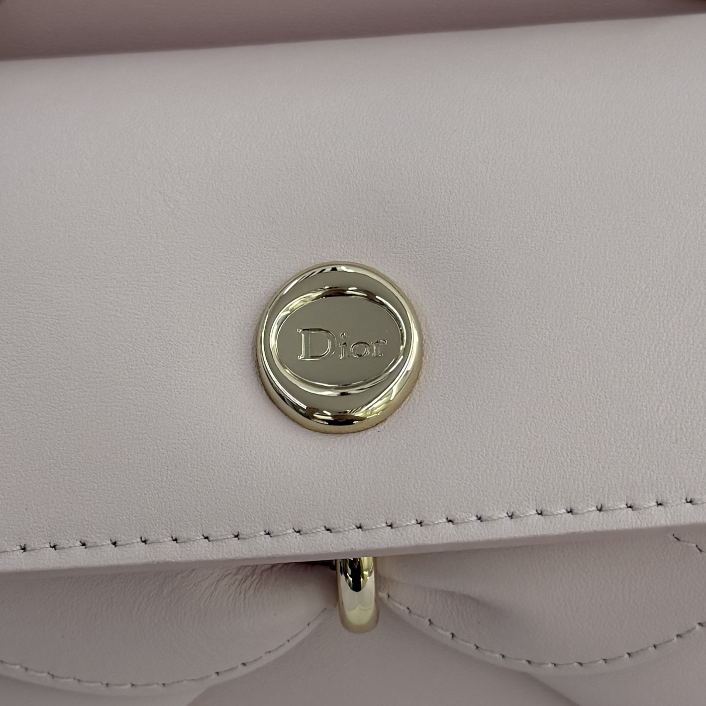 Dior 2026蝴蝶结手提包_编号7038_淡粉色金扣
🎀 Dior 2026 春夏新品#蝴蝶结手提包「淡粉色」
新设计的轮廓与造型，配色 丰富，适配多人！在夸张与优雅之间恰到好处！它的设计灵感源于迪奥先生设计的 Cigale礼服~立体的梯形包身+单手柄，造型自带优雅大气的腔调。包包的外观比较低调，几乎没有什么明显的大Logo。离近点再看，才发现原来Anderson把Dior字母Logo和包包提手的圆孔融合到了一起。
包包既有辨识度，也完全不是张扬挂的，整体散发着那种不动声色的高级感！值得一提的是，这款包还搭配了一条皮质长肩带。尤其出门旅行的时候就可以换上长肩带，既解放了双手，还衬得人轻松又随性~
型号：7038
尺寸：28*10*22（长*宽*高）