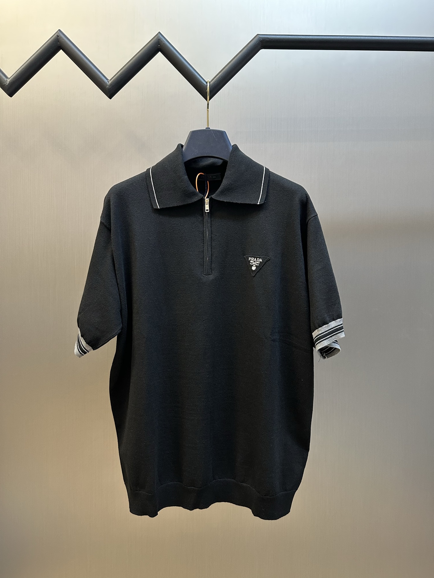 NO:868742,.Prada Triangle Logo Zipper Sweater is made of custom-woven cloud-soft double-woven cotton yarn, with three-dimensional Prada triangle logo embroidery on the chest. The half-open zipper breaks the dull style. The collar inlay and the contrasting stripes on the cuffs echo each other. The restrained color contrast injects a smart edge into the calm texture without deliberately showing off.  The overlapping embroidery process is made of jacquard tissue imported from Germany. The yarns of the same color are woven into the knitted fabric base, and then the high-precision flat embroidery process is used to carefully interweave on the loom. The Pd logo jacquard art pattern is inlaid, making the fabric more vivid and three-dimensional. size46.48.50.52,,prada,prada,sweaters,19860909.Prada 普拉达 三角徽标拉链毛衣 定织云柔双织棉毛纱,胸口立体刺绣prada三角徽标,半开拉链打破沉闷定式,领口嵌线与袖口撞色条纹呼应成趣,用克制的色彩对比,为沉稳质感注入灵动锋芒,无需刻意张扬. 叠织浮绣工艺,优先德国进口机提花组织而成,以同色系纱线织入针织面料基底,再采用高精密平绣工艺,在织机上精心交织,Pd徽标提花艺术图案镶饰,织物更加生动立体. size46.48.50.52,,prada,prada,sweaters,,Men's clothing