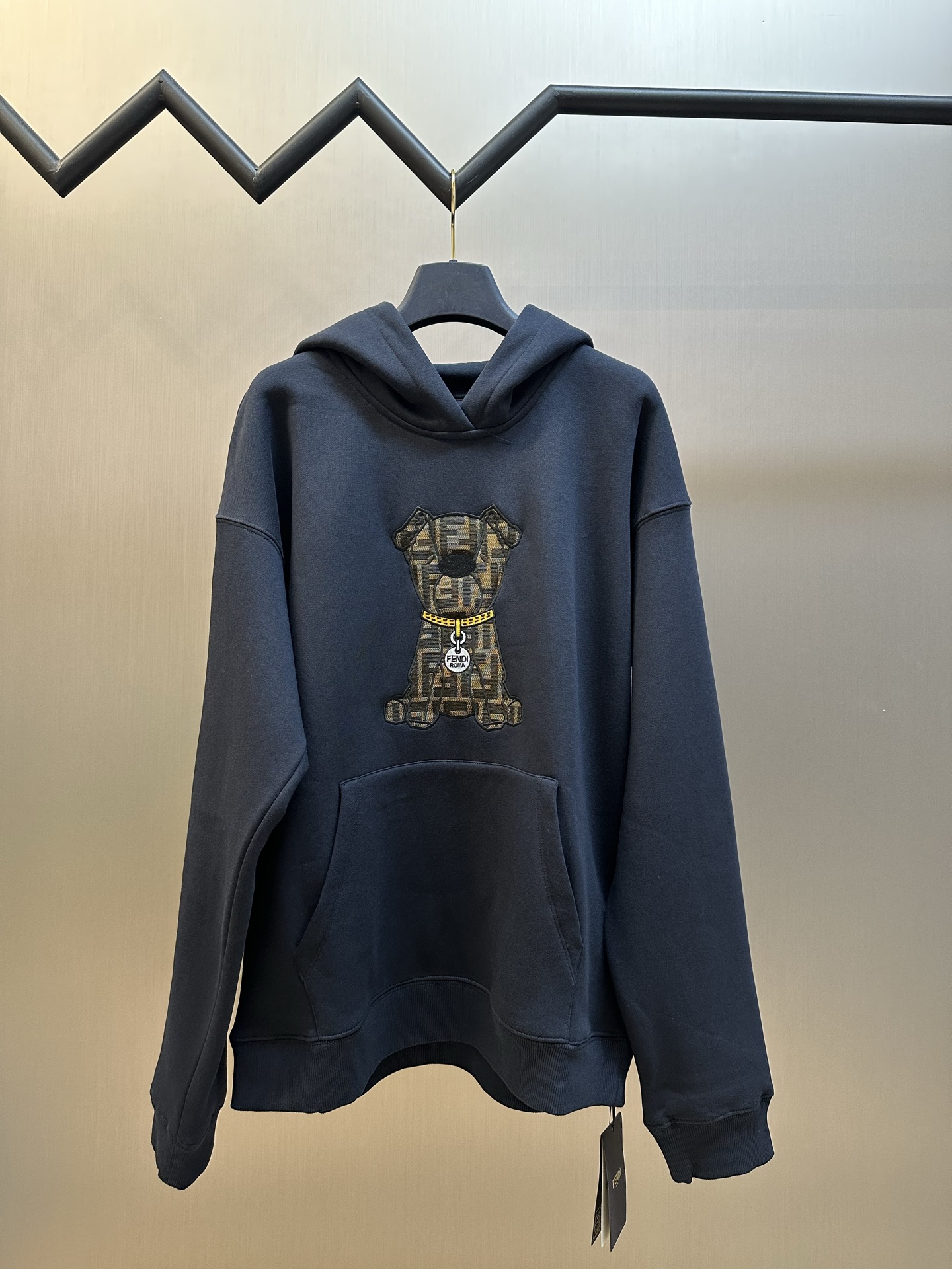 p215 FD 老花FF爱犬连帽卫衣 定制奢感云绒棉混纺针织，以深海谧蓝为底，织就罗马的沉静夜色，雾感云绒肌理包裹着意式松弛，胸前标志性爱犬Ito刺绣翩然铺陈，经典双F纹样交织复古荣光，金色项圈缀以金属吊牌，于灵动细节间镌刻FD贵族气韵。…