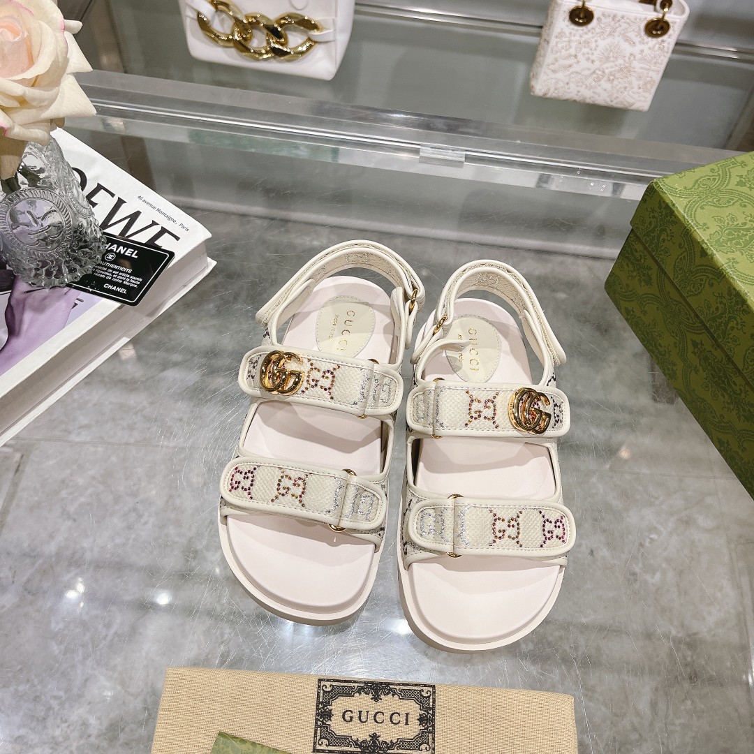 NO:167121,8818-5 Women's White G-Silver (35-41) This flat sandal is made of magic sticky tape design, which is modern and full of sporty atmosphere, bringing a comfortable feeling. This accessories are ingeniously crafted by ivory white GG crystal canvas, with elegant double G-shaped accessories on the upper ties embellished with elegant double G-shaped accessories to show a unique style. Ivory white GG crystal canvas Women's gold tone accessories Double G rubber sole The back is magic sticky buckle-closed, and the front is fixed with straps Flat, sandals, sandals198609098818-5女白G银（35-41）这款平底凉鞋采用魔术粘带设计,现代感十足且充满运动气息,带来舒适感受.这款配饰以象牙白色GG水晶帆布匠心打造,鞋面绑带缀饰雅致的双G造型配件,展现别致风采. 象牙白色GG水晶帆布 女士 金色调配件 双G 橡胶鞋底 背面采用魔术粘扣开合,正面采用绑带固定 平底,凉鞋,sandals,Women's Shoes