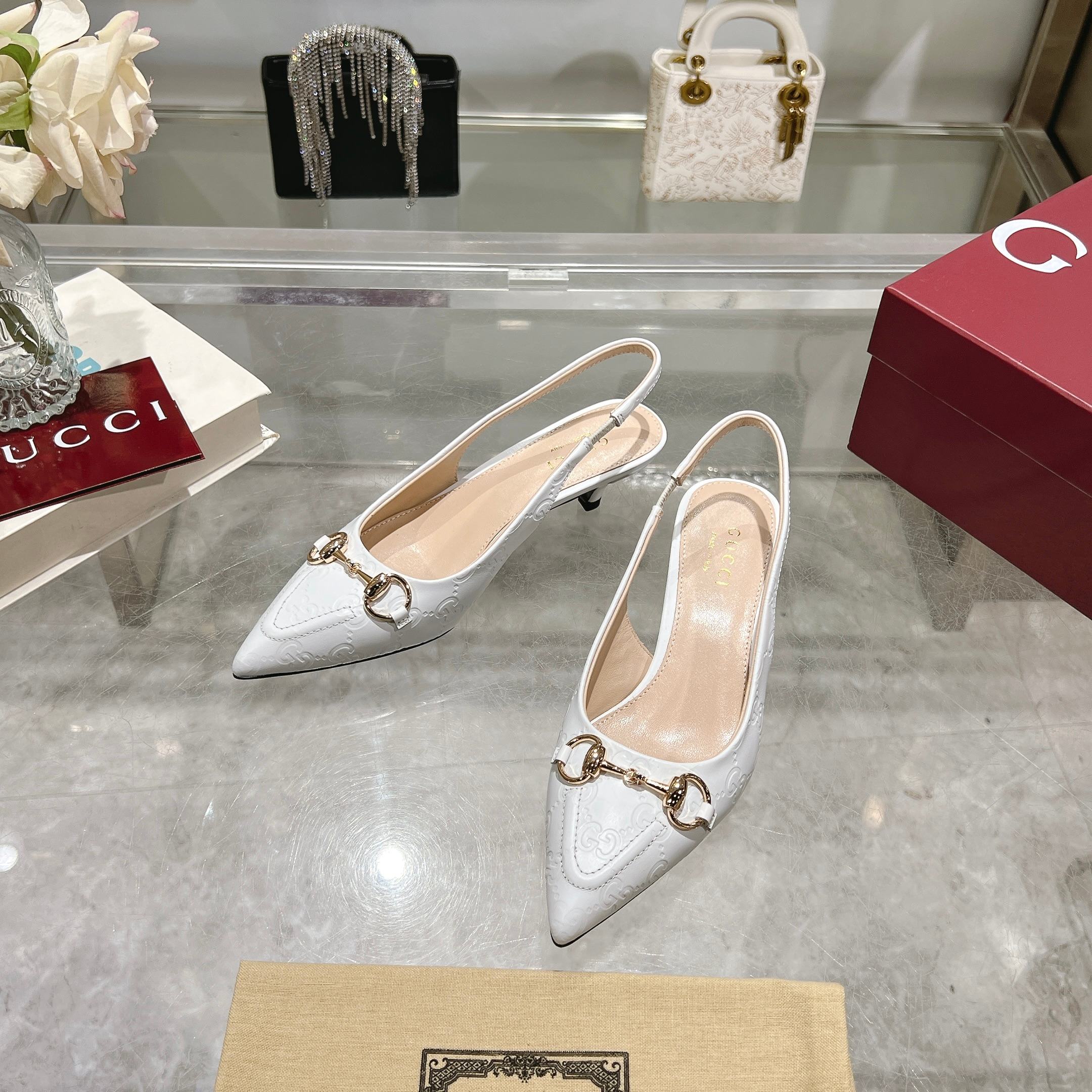 NO:261962,-1* White (35-41) This elegant high heel with exposed heels is made of white GG leather. The recognizable brand element horse buckle adds a bright embellishment to the center of the shoe. The pointed toe is paired with elastic straps, and the low heel design creates a comfortable fit. White GG leather Women's Light gold tone accessories Leather lining Horse buckle Pointed toe Toe Details Elastic straps Low heels, sandals, sandals, high heels19860909-1* 白（35-41）这款优雅的露跟高跟鞋甄选白色GG皮革匠心制作,颇具辨识感的品牌元素马衔扣为鞋履中央增添亮眼点缀.尖形鞋头搭配松紧系带,低跟设计打造舒适版型. 白色GG皮革 女士 浅金色调配件 皮革衬里 马衔扣 尖形鞋头 面线细节 松紧绑带 低跟,凉鞋,sandals,high heels,Women's Shoes