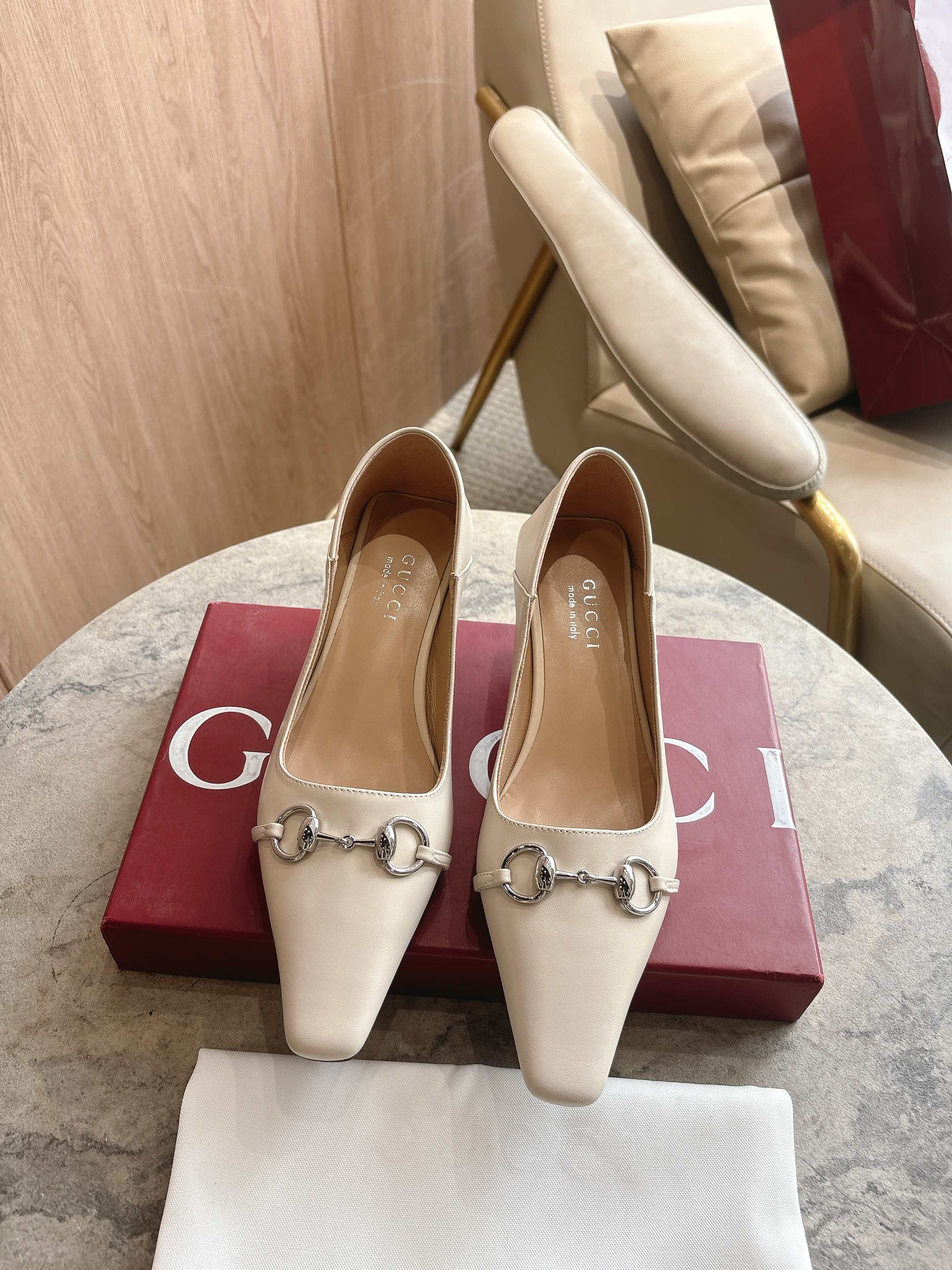 NO:749465,3570-1 white (35-42) 2026 spring and summer series is newly launched. The Vittoria series presents an outstanding soft shoe silhouette with a simple and neat extended toe and tapered heel, adding a dazzling new work to 'La Famiglia'. This shoe is made of soft leather, and the back can be folded down, showing a casual and elegant charm. The name of the shoe is derived from this design ingenuity. Off-white leather Silver tone accessories  Beige leather lining Horsebit buckle and 'Made in Italy by Gucci' logo with matching metallic finish Extended micro-square toe Leather sole Leather-covered tapered heel with metal plate Medium heel Height 5.5 cm, single shoe, gucci198609093570-1 白（35-42）2026春夏系列全新上市.Vittoria系列以简约利落的加长鞋头与锥形鞋跟匠心呈献出众柔软的鞋履廓形,为《La Famiglia》增添亮眼新作.这款鞋履甄选柔软皮革打造,后帮可向下翻折,一展随性优雅气韵.其鞋款名称正源于此设计巧思. 米白色皮革 银色调配件 米色皮革衬里 马衔扣和同款金属质感饰面“Made in Italy by Gucci”标识 加长微方鞋头 皮革鞋底 皮革包覆锥形鞋跟,饰金属片 中跟 高度5.5厘米,单鞋,gucci,Women's Shoes