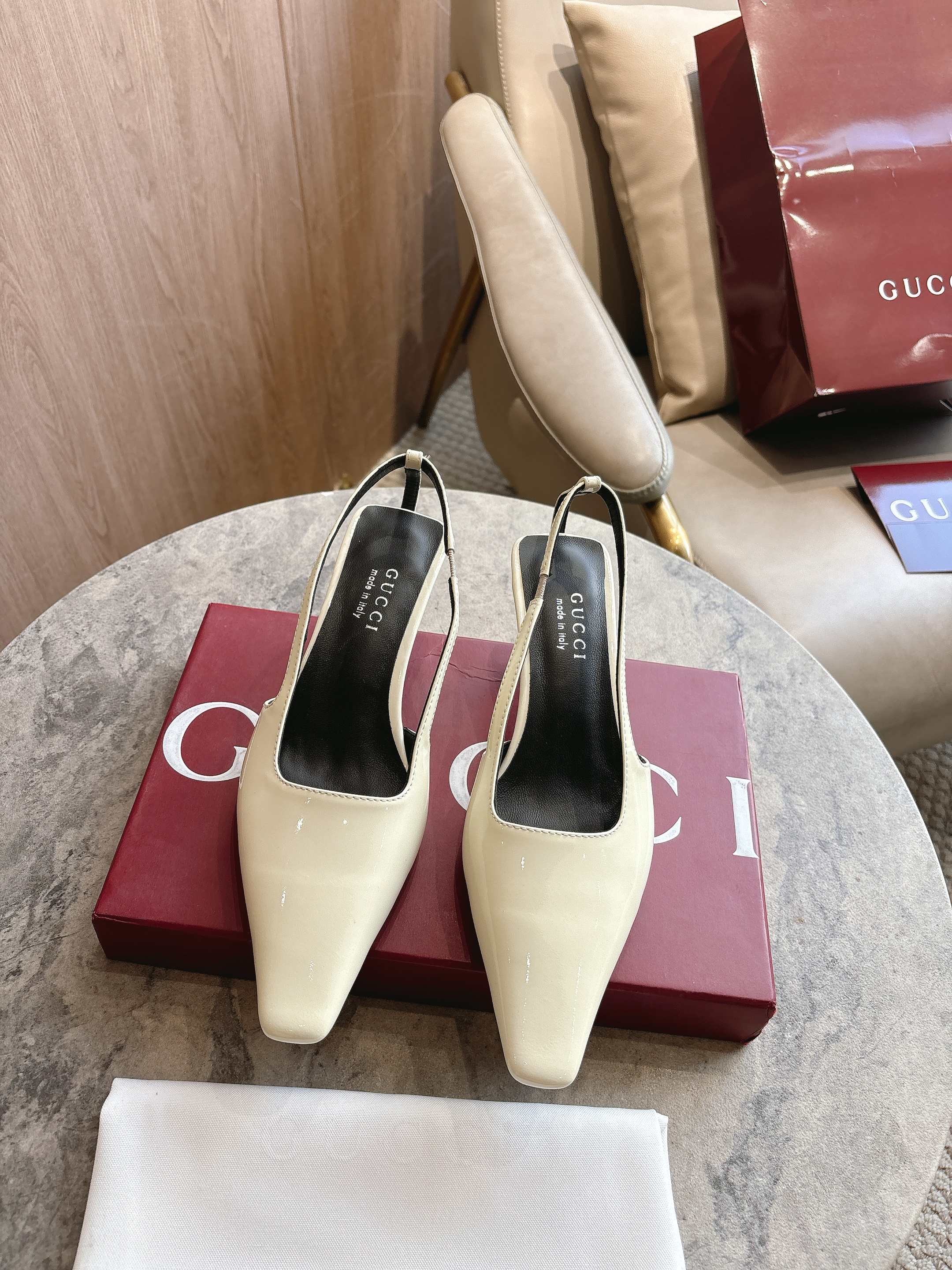 NO:749449,3570-2 G (25-42) This sling-back shoe debuted in the 2026 early spring series fashion show. The elongated square toe silhouette is an ingenious interpretation of the rich charm of the 1990s. The shoes draw inspiration from the brand's archive design and are decorated with a crystal logo metal patch on the back of the right heel, highlighting a unique style. White glossy leather Leather lining Crystal logo metal patch on the back of the right heel Extended rectangular toe Square upper  Leather sole, cat heel, 5.5 cm high, sandals, sandals198609093570-2 G（25-42）这款后系带鞋于2026早春系列时装秀首度亮相,加长方头廓形匠心诠释20世纪90年代的繁美风韵.鞋履汲取品牌典藏设计灵感,右鞋跟后方饰有仿水晶标识金属饰片,彰显别致格调. 白色亮面皮革 皮革衬里 右鞋跟后方饰仿水晶标识金属饰片 加长方形鞋头 方形鞋面 皮革鞋底 猫跟型中跟 5.5厘米高,凉鞋,sandals,Women's Shoes