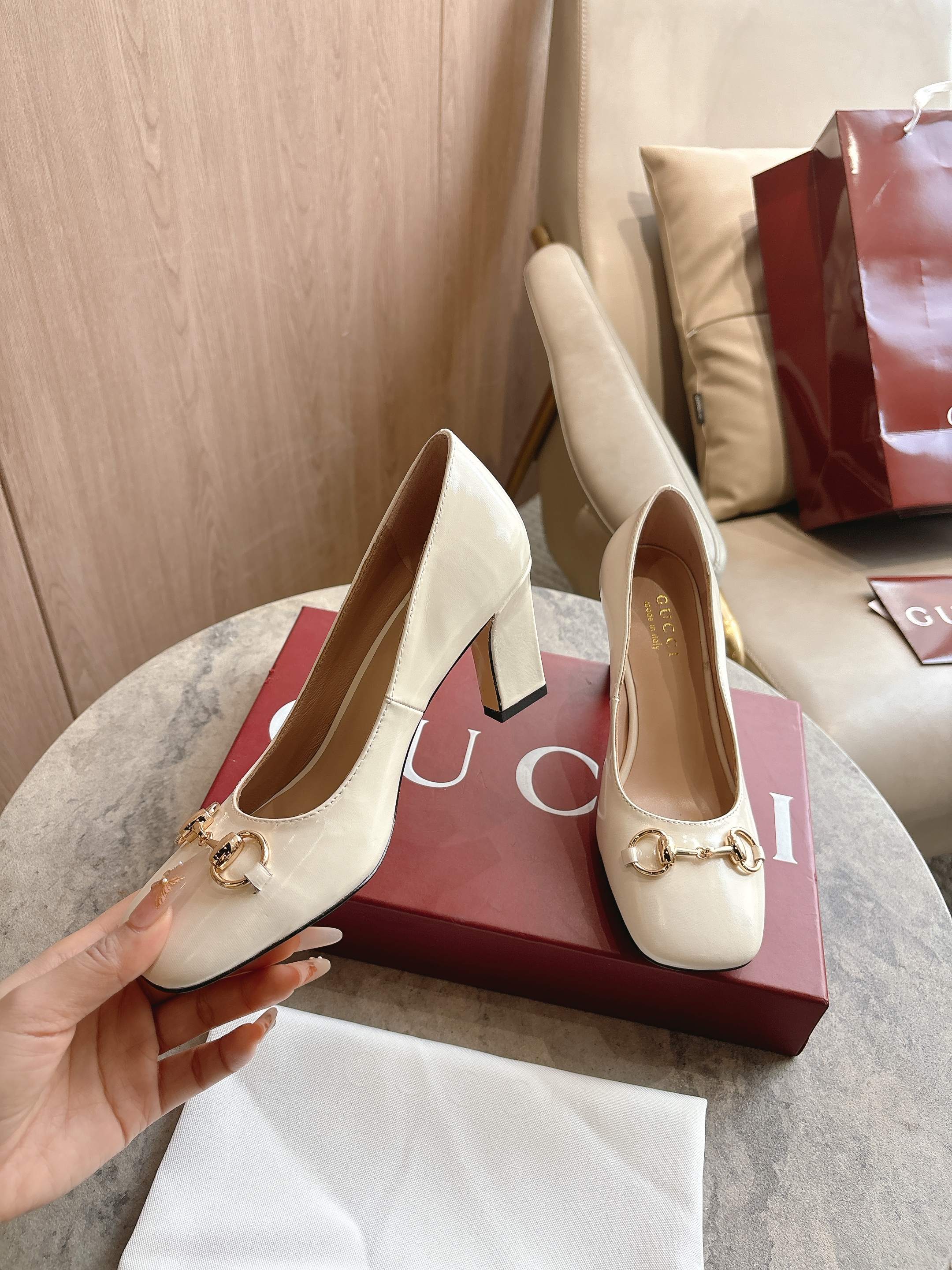 NO:749542,3079-2 White (35-42) is newly launched in the 2026 spring and summer series. This single product appears in the 'Incazzata' look of the 'La Famiglia' series. The design of the Signora series of shoes is inspired by the word 'lady' in Italian. It reinterprets the brand's archive pumps with a simple and neat square toe and a slim and slender thick heel, injecting a modern flavor into the elegant style. Off-white soft glossy leather Gold tone accessories Pink leather lining  Horsebit buckle and 'Made in Italy by Gucci' logo with the same metallic finish. Clean square toe. Leather sole. Slim wide heel silhouette. Medium heel. Heel height 850 cm. Single shoes, gucci198609093079-2 白（35-42）2026春夏系列全新上市.这款单品亮相于《La Famiglia》系列“Incazzata”造型.Signora系列鞋履的设计灵感源自意大利语中的“夫人”一词,以简约利落的方形鞋头与纤细修长的粗跟焕新演绎品牌典藏浅口鞋,为雅致风尚注入一抹现代气息. 米白色柔软亮面皮革 金色调配件 粉色皮革衬里 马衔扣和同款金属质感饰面“Made in Italy by Gucci”标识 利落方形鞋头 皮革鞋底 修长阔跟廓形 中跟 跟高850厘米,单鞋,gucci,Women's Shoes