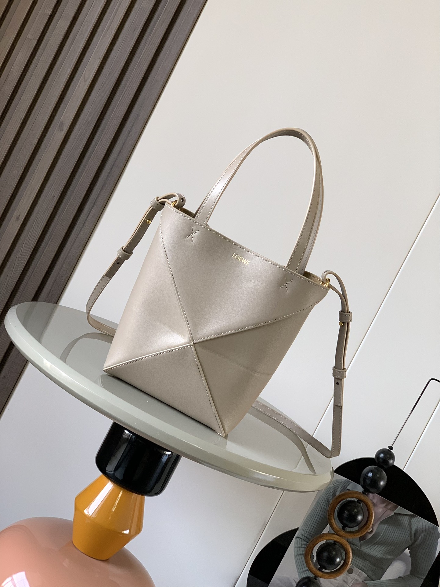 NO:203830,Original leather New shiny cowhide leather mini puzzle Fold handbag has played geometric shapes for a long time and hasn't seen such a practical and design-filled tote bag. This model continues the geometric aesthetics of the Puzzle series, inspired by origami bags, making this Puzzle Fold tote a random switch between three-dimensional and flat surfaces. The leather is very delicate and glossy. It is also a light weight. In addition, it can be folded. Puzzle Fold handbag draws inspiration from the geometric lines of the brand's classic handbag series and uses creativity to reinterpret it into a fashionable tote bag. It can be completely folded. This mini version is made of soft shiny cowhide. Size 20CM~16.5CM~9CM Model number 9030 Color grit color, Loewe, totes, cowhide19860909原厂皮 新款亮面牛皮革迷你号puzzle Fold手袋又把几何图形玩出花了很久没见过这么实用又设计感满满的托特包了这款延续了Puzzle系列的几何美学以折纸包为灵感,让这只 Puzzle Fold tote 在立体和平面随意切换皮质都很细腻光泽本身自重超轻,外加可以折叠Puzzle Fold手袋从品牌经典手袋系列的几何线条汲取灵感运用创意巧思将其重新诠释为一款时尚的托特袋,能完全折叠是旅行良伴.这个迷你号版本采用柔软的亮面牛皮革打造 尺寸20CM～16.5CM～9CM 款号9030 颜色砂砾色,罗意威,loewe,totes,cowhide,Bag