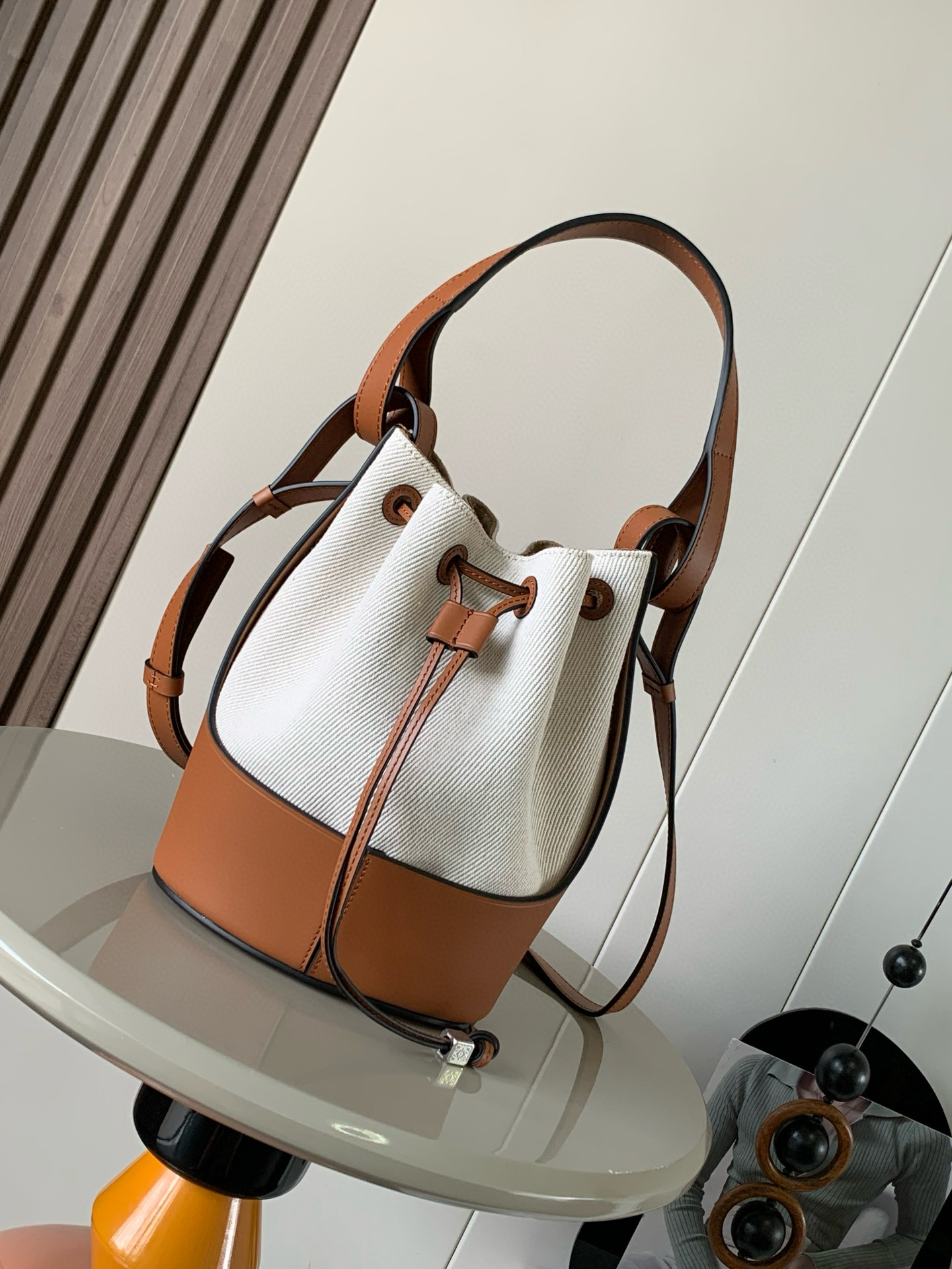 NO:205523,Genuine Balloon new small canvas bucket balloon bag It looks like a bucket bag, using strong calfskin as a round bottom, plus napa soft cowhide to make the bag body, leather knock-in comfortable, delicate and soft, making its outline like a round balloon, and there is also a Loewe Anagram dice on the shackle rope as a highlight. Structural but relaxed drawstring bag. The balloon uses intriguing structure to achieve a classic proportion and clean lining. The rigid external base supports the soft inner capsule to ensure a solid design to accommodate a soft inner bag. It is lightweight and comfortable to wear. This version is made of raffia and cowhide leather. The shoulder strap is adjustable and has a adjustable belt close. Crossbody or hand-carrying, with multiple backing methods. Fashionable and age-reducing and versatile. Size 25cm~18cm~13cm Model No. 9083  Color rice apricot canvas brown, Loewe, loewe, cowhide19860909正品级 Balloon 新款小号帆布水桶气球包 它外观看上去就像是水桶包,使用了强韧的小牛皮作为圆形底部,再加上napa软牛皮制作袋身,皮质敲级舒服,细腻柔软,让它的轮廓就像圆圆的气球一样,打结皮绳上还有一颗Loewe Anagram骰子作为亮点结构化但轻松的拉绳袋,气球使用耐人寻味的结构来实现一个经典的比例和干净的衬里轮廓刚性的外部底座支撑着柔软的内囊确保了坚固的设计可容纳柔软的内部包身.重量轻,佩戴舒适.这个版本由酒椰纤维和牛皮革制成*肩带可调节束带关闭.斜挎或手拎携带,多种背法*时尚减龄又百搭 尺寸25cm～18cm～13cm 款号9083 颜色米杏帆布棕,罗意威,loewe,loewe,cowhide,Bag