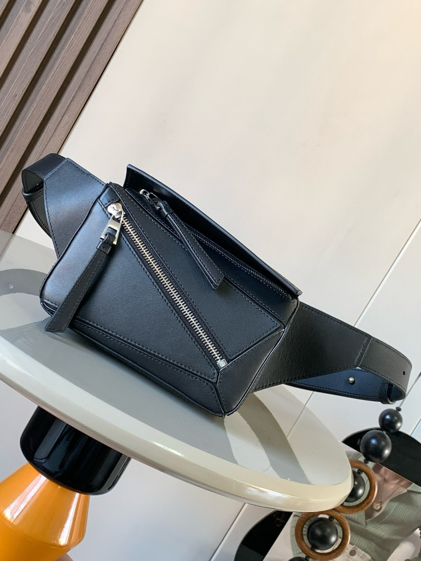 NO:206587,Mini classic cowhide leather Puzzle waist bag rectangular shape and precise cutting technology create Puzzle's unique geometric lines. This small mini waist bag is made of classic cowhide leather. It is soft and light. It has a low-key and recognizable shape. It can be matched with both business and casual. Later, I found a puzzle waist bag. Compared with classic, Puzzle is relatively niche. This waist bag removes the handle of the classic puzzle. The rear zipper bag at the back of the classic puzzle. The belt belt is also unremovable. The wide belt retains the basic bag shape of the classic puzzle. In addition, the fork adds a cool mechanical feel. It is also classic and versatile. Not only is the capacity considerable, but the upper body proportions are better. The shoulder or crossbody, adjustable shoulder straps are equipped with metal buckle closure. Size 18CM~12CM~7.5CM  Model number 8013 Color black, Loewe, cowhide19860909迷你号经典牛皮革 Puzzle 腰包长方体形状和精确的切割技术创造了Puzzle 独特的几何线条这款小迷你号腰包采用经典牛皮革制成皮质柔软轻便,造型低调有辨识度不管是商务还是休闲都可以搭配后来叉发现一款 puzzle腰包,相对经典,puzzle 来说比较小众此款腰包去掉了经典puzzle的手柄把经典puzzle 后面的后置拉链袋移到了前面腰带也变成不可拆卸插销扣宽腰带保留经典puzzle随性文艺的基本包型外,叉增加了一份酷酷的机械感同样经典百搭.不仅容量可观而且上身比例更好.肩背或斜挎 ,可调节肩带,配有金属搭扣开合 尺寸18CM～12CM～7.5CM 款号8013 颜色黑色,罗意威,loewe,cowhide,Bag