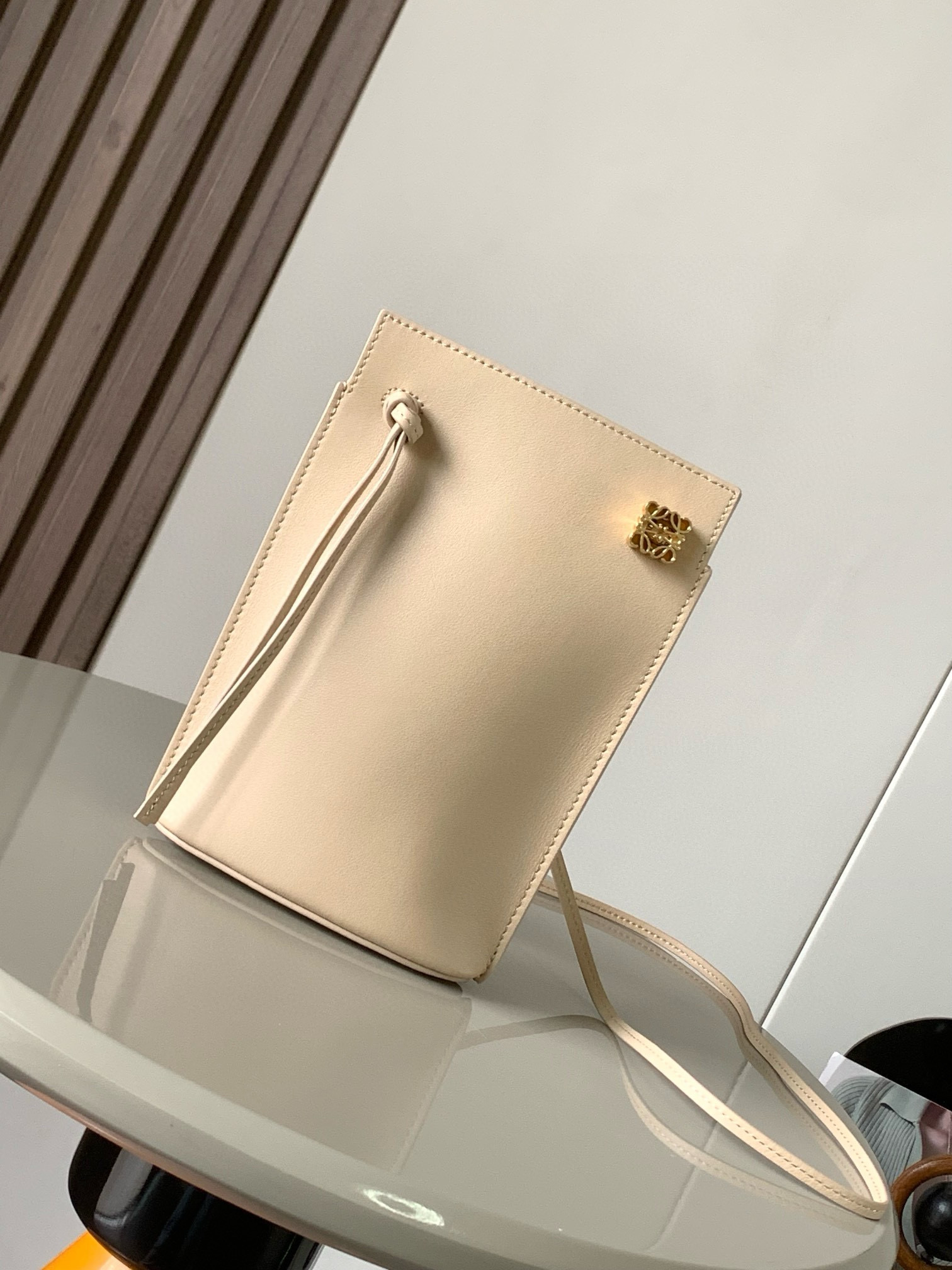 NO:206578,Dice pocket cowhide dice mobile phone bag imported from the original Napa calf leather practical bag is equipped with shoulder straps and Anagram three-dimensional logo. It can be shoulder-mounted or cross-body, with two leather straps. It can be added with personalized dice decoration. The base is embossed with L0EWE steel stamp. The overall simple and generous leather is hard and not easy to deform. The top layer of cowhide is delicate and shiny. The whole bag is made of full-head layer of cowhide material, with a sturdy three-dimensional gold metal logo. The decoration is low-key and luxurious. The capacity inside is quite large. It can be equipped with a large screen mobile phone with a large screen, lipstick. Size 20.5~13~4.5CM. Model number 9027. Ivory, Loewe, loewe, cowhide.19860909dice pocket牛皮骰子手机包原厂进口纳帕小牛皮实用小包配有肩带和Anagram立体Logo可肩背或斜挎,带有两条皮革带子,可添加个性化骰子装饰串珠底座上带有L0EWE钢印压纹,整体简约大方皮质是偏硬的,不容易变形,头层牛皮,皮质细腻有光泽,整个包包都是全头层牛皮材质包身硬挺有型立体金色金属logo装饰低调奢华,里面的容量还挺大的,可以装大屏手机的大屏手机,口红 尺寸20.5～13～4.5CM 款号9027 颜色象牙色,罗意威,loewe,cowhide,Bag