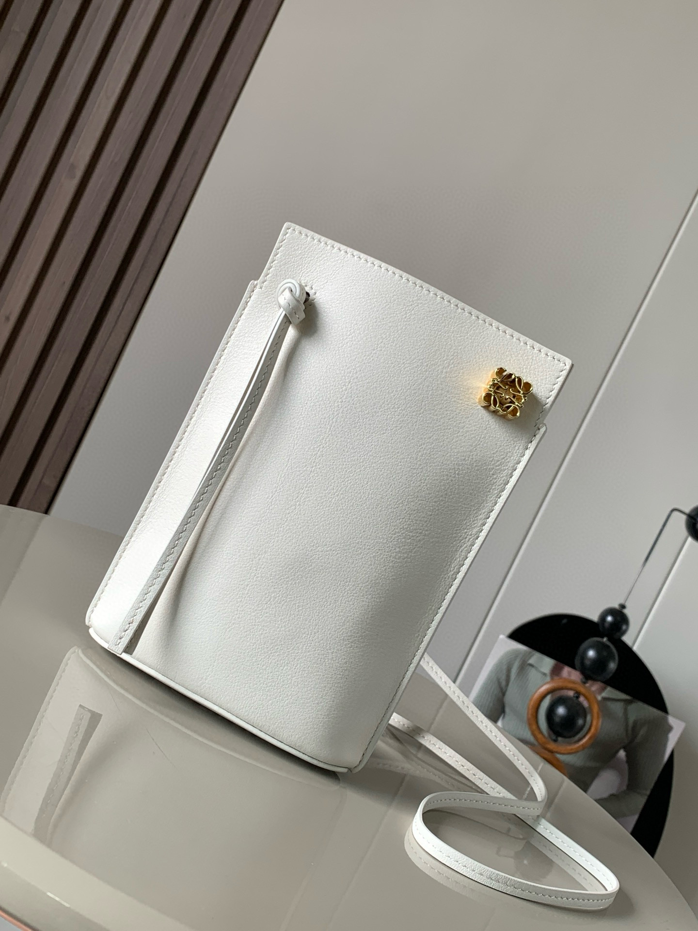 NO:206604,Dice pocket cowhide dice mobile phone bag imported from the original Napa calf leather practical bag is equipped with shoulder straps and Anagram three-dimensional logo. It can be shoulder-mounted or cross-body, with two leather straps. It can be added with personalized dice decoration. The base is embossed with L0EWE steel stamp. The overall simple and generous leather is hard and not easy to deform. The top layer of cowhide is delicate and shiny. The whole bag is made of full-head layer of cowhide material, with a sturdy three-dimensional gold metal logo. The decoration is low-key and luxurious. The capacity inside is quite large. It can be equipped with a large screen mobile phone with a large screen, lipstick. Size 20.5~13~4.5CM. Model number 9027. Color white, Luo Yiwei, loewe, cowhide19860909dice pocket牛皮骰子手机包原厂进口纳帕小牛皮实用小包配有肩带和Anagram立体Logo可肩背或斜挎,带有两条皮革带子,可添加个性化骰子装饰串珠底座上带有L0EWE钢印压纹,整体简约大方皮质是偏硬的,不容易变形,头层牛皮,皮质细腻有光泽,整个包包都是全头层牛皮材质包身硬挺有型立体金色金属logo装饰低调奢华,里面的容量还挺大的,可以装大屏手机的大屏手机,口红 尺寸20.5～13～4.5CM 款号9027 颜色白色,罗意威,loewe,cowhide,Bag