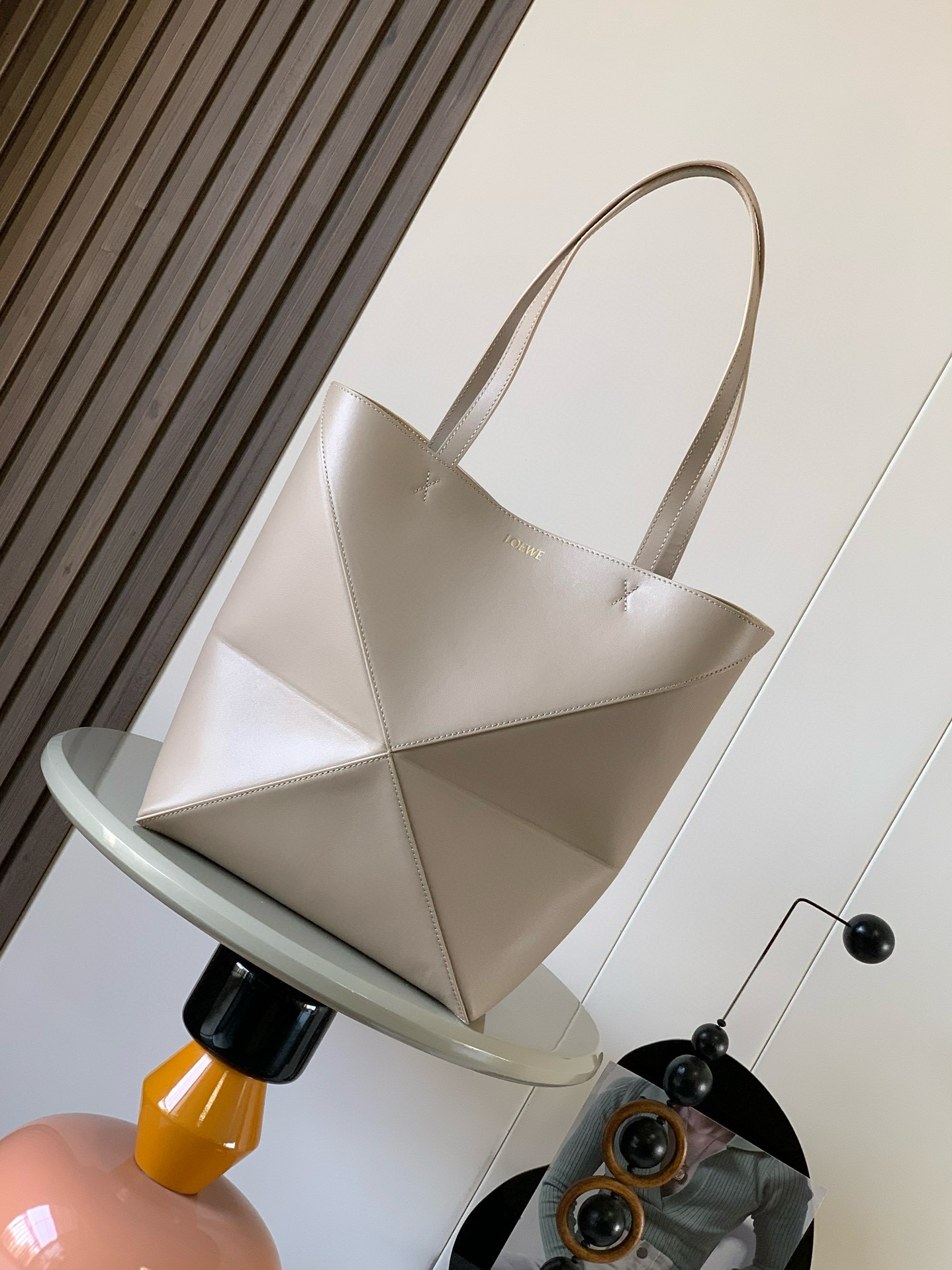 NO:207025,Genuine Grade New Glossy Cowhide Leather Puzzle Fold Handbag has played geometric figures for a long time. I haven't seen such a practical and design-filled Tote. This Puzzle Fold Tote continues the geometric aesthetics of the Puzzle series, inspired by origami bags, allowing this Puzzle Fold tote to switch the upper body in three-dimensional and flat surfaces. Two sizes are for reference. Large size is more friendly and the small size is cute. The leather is delicate and the gloss is super light. In addition, it can be folded and is suitable for commuting with computers, or for daily business trips, it is effortless to store for trunk Puzzle Fold Handbag draws inspiration from the geometric lines of the brand's classic handbag series. It uses creativity and ingenuity to reinterpret it into a fashionable tote bag. It can be completely folded. This medium version is made of soft glossy cowhide Leather.  Size 31~25~14CM Model number 9029 Color gravel color, Loewe, totes, cowhide19860909正品级 新款亮面牛皮革puzzle Fold手袋又把几何图形玩出花了很久没见过这么实用又设计感满满的托特包了这款延续了Puzzle系列的几何美学以折纸包为灵感,让这只 Puzzle Fold tote 在立体和平面随意切换上身了两个尺码给大家参考哦大号容量更友好小号很可爱,皮质都很细腻光泽本身自重超轻,外加可以折叠太适合平时带电脑通勤,或是像我一样经常出差旅行不费力的收纳进行李箱Puzzle Fold手袋从品牌经典手袋系列的几何线条汲取灵感运用创意巧思将其重新诠释为一款时尚的托特袋,能完全折叠是旅行良伴这个中号版本采用柔软的亮面牛皮革打造 尺寸31～25～14CM 款号9029 颜色砂砾色,罗意威,loewe,totes,cowhide,Bag