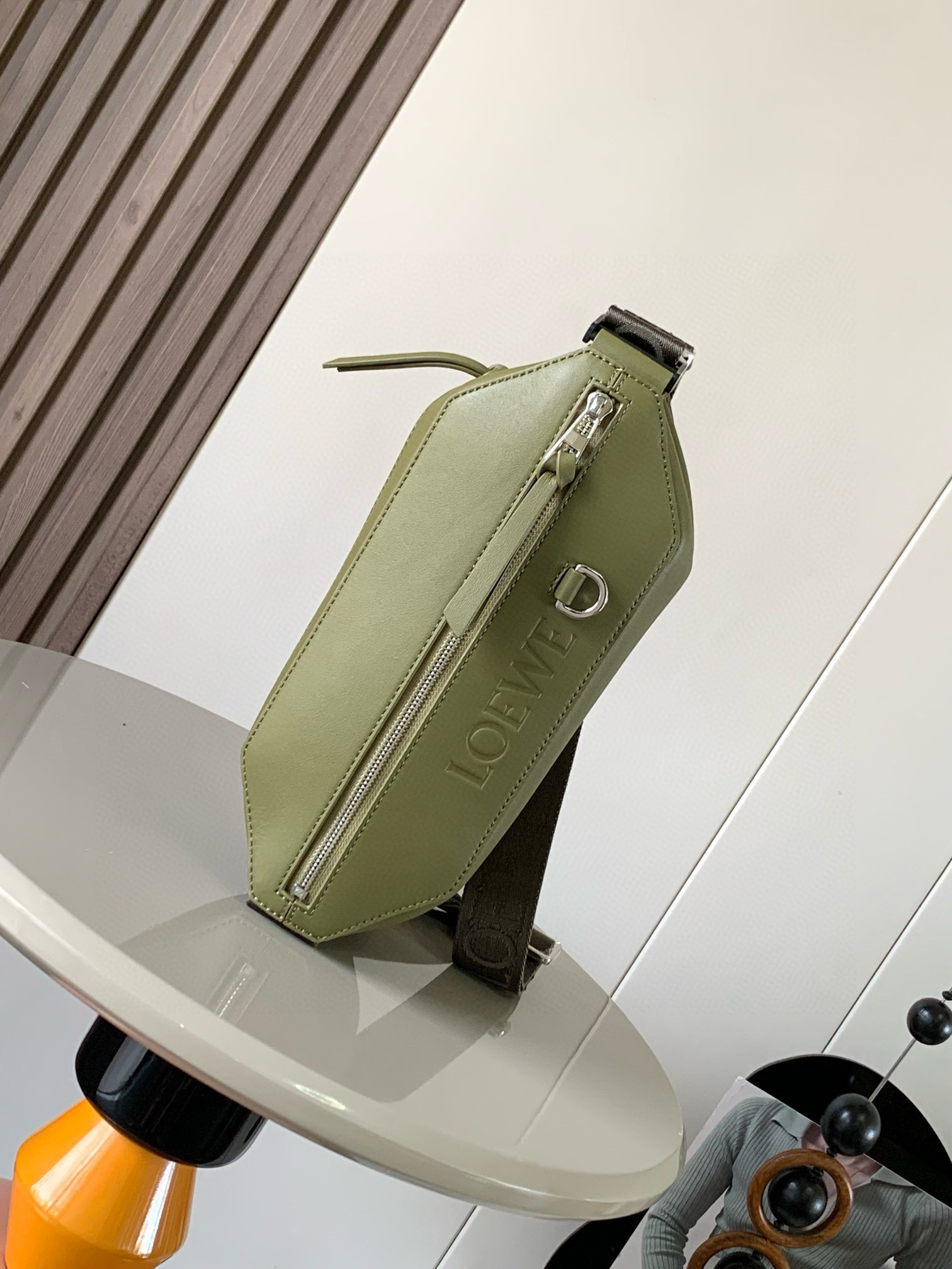 NO:208315,Classic cowhide Sling handbag Compact Sling handbags with adjustable LOEWE webbing and brand logo metal buckles can be opened to change the bag capacity and enable multiple ways to carry. External zipper flat pockets improve functionality This version is made of classic cowhide leather. * Can be carried cross-body or as a waist bag * Zipper opening and closing, cowhide zipper head * Herringbone cotton canvas lining * Embossed with D-ring LOEWE Size 32.5cm ~ 9cm ~ 12.3cm Model No. 9074 Color Olive Gray, Loewe, loewe, cowhide19860909经典牛皮革变形 Sling 手袋 紧凑型 Sling 手袋配有可调节 LOEWE 织带和品牌标志金属搭扣可打开以改变手袋容量并实现多种携带方式.外部拉链平口袋进步增强了功能性这个版本采用经典牛皮革制成.＊可斜挎或作为腰包携带＊拉链开合,牛皮革拉链头＊人字纹棉质帆布衬里＊配有 D 形环的压纹 LOEWE 尺寸32.5cm～9cm～12.3cm 款号9074 颜色橄榄灰,罗意威,loewe,loewe,cowhide,Bag