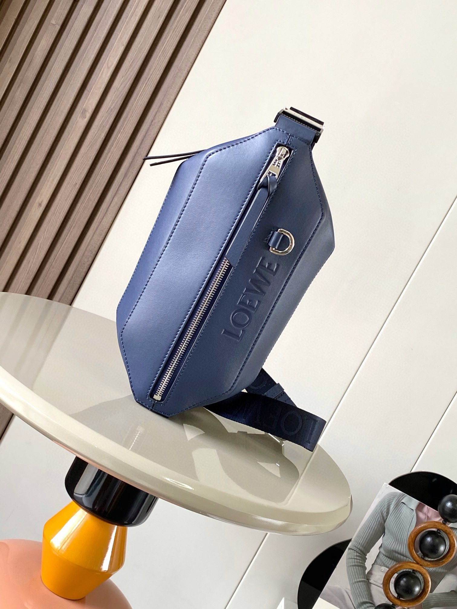 NO:208319,Classic cowhide Sling handbag Compact Sling handbags with adjustable LOEWE webbing and brand logo metal buckles can be opened to change the bag capacity and enable multiple ways to carry. External zipper flat pockets improve functionality This version is made of classic cowhide leather. * Can be carried cross-body or as a waist bag * Zipper opening and closing, cowhide zipper head * Herringbone cotton canvas lining * Embossed with D-ring LOEWE Size 32.5cm ~ 9cm ~ 12.3cm Model No. 9074 Color Navy, Loewe, loewe, loewe, cowhide19860909经典牛皮革变形 Sling 手袋 紧凑型 Sling 手袋配有可调节 LOEWE 织带和品牌标志金属搭扣可打开以改变手袋容量并实现多种携带方式.外部拉链平口袋进步增强了功能性这个版本采用经典牛皮革制成.＊可斜挎或作为腰包携带＊拉链开合,牛皮革拉链头＊人字纹棉质帆布衬里＊配有 D 形环的压纹 LOEWE 尺寸32.5cm～9cm～12.3cm 款号9074 颜色海军蓝,罗意威,loewe,loewe,cowhide,Bag