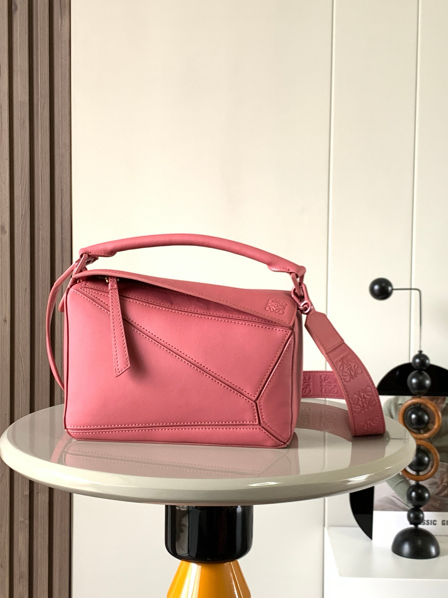 NO:208332,Geometric bag 24CM wide shoulder strap embossed Puzzle handbag original imported calfskin plain pattern Luojia hot-style geometric bag Puzzle handbag is the first handbag for L0EWE, the first handbag for L0EWE, the rectangular shape and precise cutting technology. Puzzle's unique geometric lines This small-size version is made of soft grain cowhide leather, which can accommodate for example a large wallet, mobile phones of all sizes and sunglasses crossbody, shoulder back, hand hold or top handle carrying * The detachable shoulder strap is different, with straps printed with L0EWE, and the metal buckle position uses the same color as the bag to make the bag more fashionable. The overall bag still keeps the bag very light, the weight is very durable, lightweight, and can hold a lot of things, suitable for work and travel. Size 24CM~16CM~10CM Model number 9006  Color rose pink, Loewe, loewe, loewe, wallets, cowhide19860909几何包24CM宽肩带压花Puzzle手袋原厂进口小牛皮平纹 罗家爆款几何包Puzzle 手袋是创意总监乔纳森·安德森为 L0EWE 推出的首款手提包长方体形状和精确的切割技术创造了 Puzzle 独特的几何线条这个小尺寸版本采用柔软粒面牛皮革制成小号可以容纳例如一只大号钱包、所有尺寸的手机和太阳镜斜挎、肩背、手拿或顶部提手携带＊可拆卸肩带不一样的粗肩带,印有 L0EWE 字样的肩带,金属扣位置采用了与包包同一色系让包包更加时尚,整体依然保持包包很轻的重量十分耐用,轻便,能装很多东西,适合上班,旅游 尺寸24CM～16CM～10CM 款号9006 颜色玫瑰粉,罗意威,loewe,loewe,wallets,cowhide,Bag