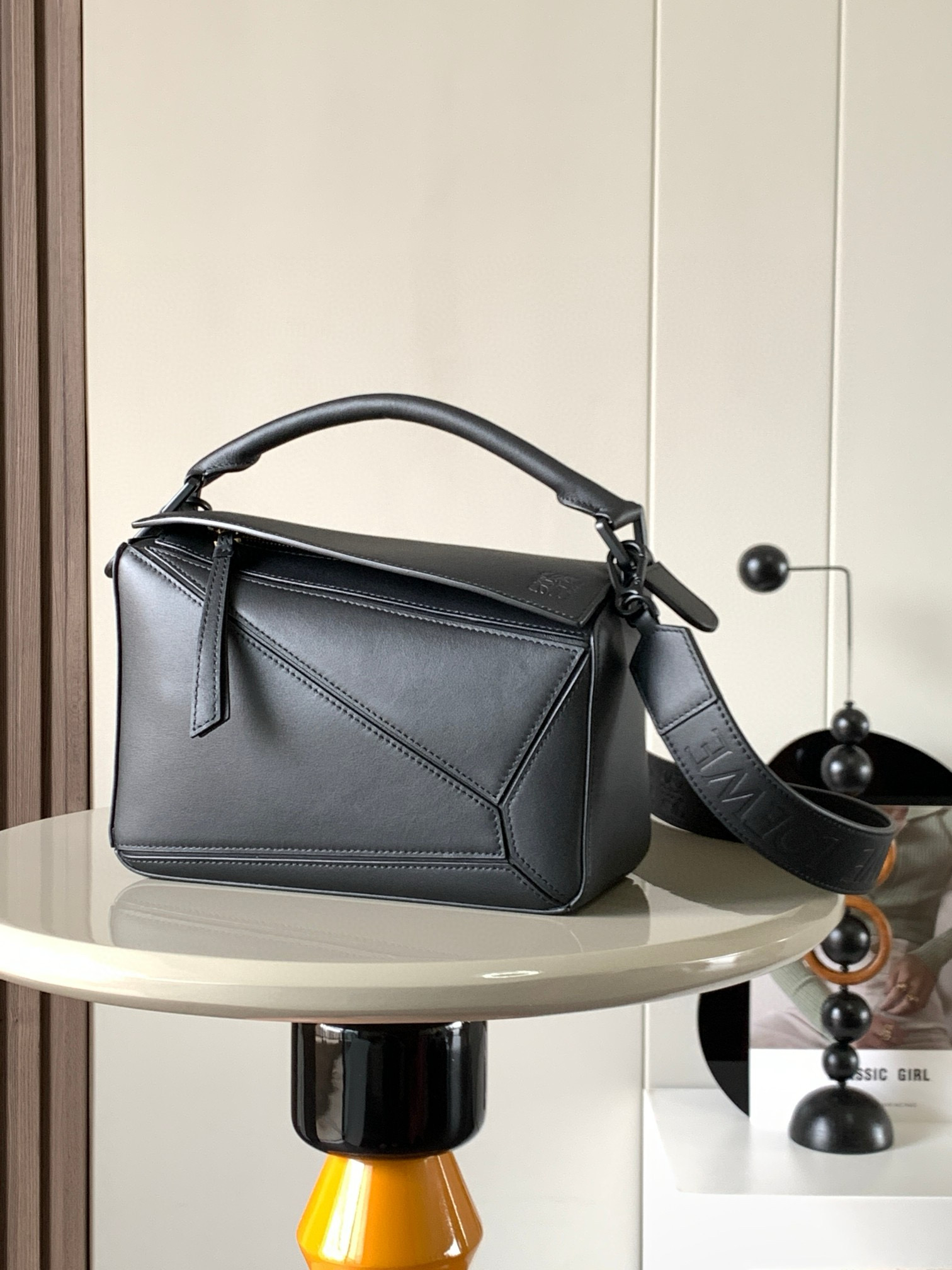 NO:208314,Geometric bag 24CM wide shoulder strap embossed Puzzle handbag original imported calfskin plain pattern Luojia hot-style geometric bag Puzzle handbag is the first handbag for L0EWE, the first handbag for L0EWE, the rectangular shape and precise cutting technology. Puzzle's unique geometric lines This small-size version is made of soft grain cowhide leather, which can accommodate for example a large wallet, mobile phones of all sizes and sunglasses crossbody, shoulder back, hand hold or top handle carrying * The detachable shoulder strap is different, with straps printed with L0EWE, and the metal buckle position uses the same color as the bag to make the bag more fashionable. The overall bag still keeps the bag very light, the weight is very durable, lightweight, and can hold a lot of things, suitable for work and travel. Size 24CM~16CM~10CM Model number 9006  Color black, Loewe, loewe, loewe, wallets, cowhide19860909几何包24CM宽肩带压花Puzzle手袋原厂进口小牛皮平纹 罗家爆款几何包Puzzle 手袋是创意总监乔纳森·安德森为 L0EWE 推出的首款手提包长方体形状和精确的切割技术创造了 Puzzle 独特的几何线条这个小尺寸版本采用柔软粒面牛皮革制成小号可以容纳例如一只大号钱包、所有尺寸的手机和太阳镜斜挎、肩背、手拿或顶部提手携带＊可拆卸肩带不一样的粗肩带,印有 L0EWE 字样的肩带,金属扣位置采用了与包包同一色系让包包更加时尚,整体依然保持包包很轻的重量十分耐用,轻便,能装很多东西,适合上班,旅游 尺寸24CM～16CM～10CM 款号9006 颜色黑色,罗意威,loewe,loewe,wallets,cowhide,Bag