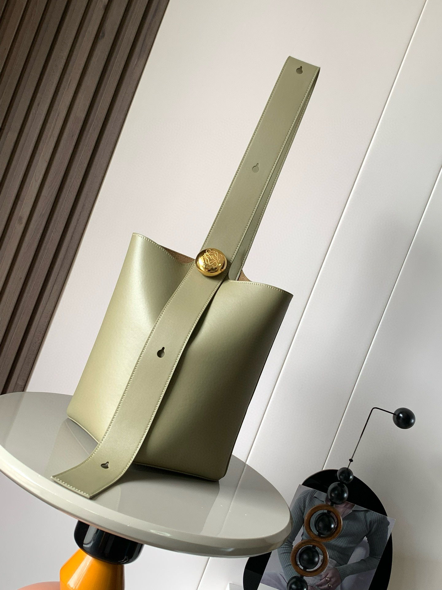 NO:208707,Medium soft cowhide leather Pebble Bucket Bag is another representative of L0EWE minimalism Bucket Bag is fashionable and simple and can be fitted with Anagram golden pebbles accessories. One feature of this bag is that the shoulder strap is very wide so it is more suitable for crossbody or like a male model on the show, holding the bag alone on the back shows freedom. Of course, wide shoulder strap is a double-door dressing welfare. One shoulder-back method is steady and neat. Pebble cleverly combines pure simple lines with eye-catching design style to create a unique and innovative handbag design. The iconic Anagram engraving hardware combines decorative and practical functions to adjust the length of the shoulder strap and is suitable for a variety of carrying methods. The unique twisted structure complements the delicate details. This medium version is made of soft cowhide leather. *Shoulder back or crossbody*Adjustable shoulder strap*Magnetic buckle closure*Inner bag 