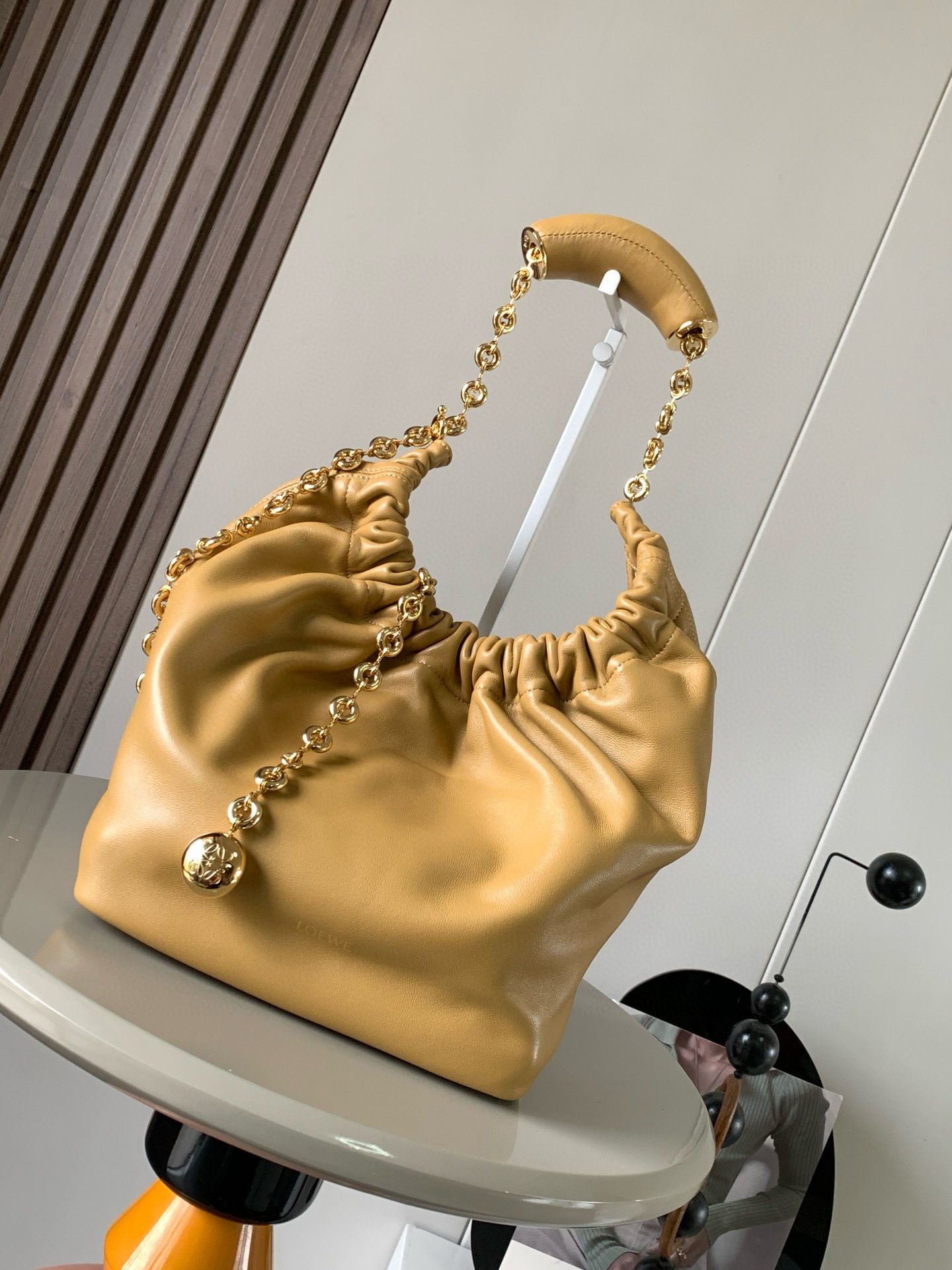 NO:209022,[Same Model in Celebrity] Small Napa Sheep Leather Squeeze Handbag is a new exquisite and soft handbag. The newly released Squeeze Handbag is made of soft and silky Mellow Napa Lambskin. The unlined structure effectively reduces the body's weight and is lighter. The meniscus shaped bag has an elegant ruffle closing, creating a relaxed and casual attitude. Another highlight of this bag is the ergonomic Squeeze airbag handle and exquisite donut chain made of brass. The length can be adjusted by chain ring or extended chain can be added, so that the airbag handles such as handcarrying, shoulders, crossbody, etc. can slide freely to improve comfort. The bottom of the chain is decorated with an Anagram Pebble pendant, adding agile details to the bag. Size 29CM~24CM~10.5CM  Model number 9042 Color sunflower yellow, Luo Yiwei, loewe, sheepskin19860909【明星同款】小号纳帕羊皮革Squeeze手袋是款精致而柔美的全新手袋全新发布的 Squeeze 手袋采用柔软丝滑的Mellow纳帕小羊皮制作而成无衬里结构有效减轻包身自重观感上也更为轻盈弯月形包口以优雅的褶边收口,营造出轻松又随性的态度这款包包还有一大亮点是符合人体工程学的 Squeeze 气囊手柄搭配黄铜打造的精美甜甜圈链条可通过链环调节长短或添加延长链,实现手拎、肩背、斜挎等不同背法气囊手柄可自由滑动位置以提升舒适度链条底部点缀一枚 Anagram Pebble 吊坠,为包包增添灵动细节 尺寸29CM～24CM～10.5CM 款号9042 颜色向日葵黄,罗意威,loewe,sheepskin,Bag