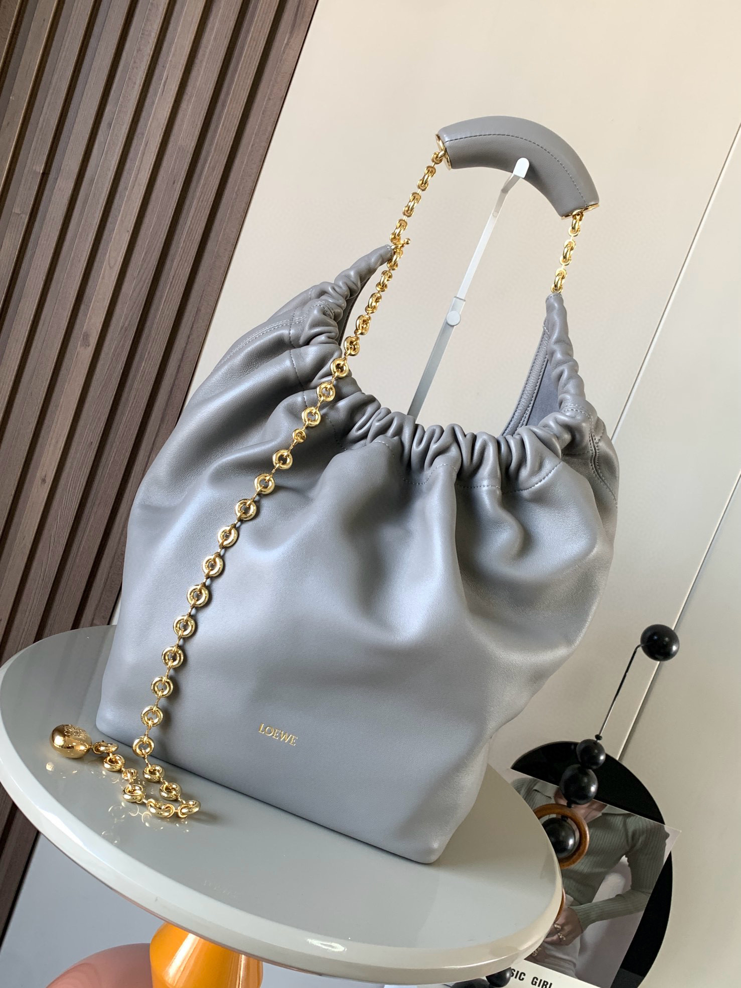 NO:209298,【Same Model for Celebrity】The medium-sized Napa Sheep Leather Squeeze handbag is a new exquisite and soft handbag. The newly released Squeeze handbag is made of soft and silky Mellow Napa Lambskin, which effectively reduces the weight of the bag. It is also lighter. The meniscus shaped bag has an elegant ruffle closing, creating a relaxed and casual attitude. Another highlight of this bag is that the ergonomic Squeeze airbag handle is matched with exquisite donut chains made of brass. The length can be adjusted by chain rings or extended chains can be added, so that the airbag handles such as handcarrying, shoulders, crossbody, etc. can slide freely to improve comfort. The bottom of the chain is decorated with an Anagram Pebble pendant, adding agile details to the bag. Size 34CM~33CM~13.5CM  Model number 9041 Color pearl gray, Loewe, sheepskin19860909【明星同款】中号纳帕羊皮革Squeeze手袋是款精致而柔美的全新手袋全新发布的 Squeeze 手袋采用柔软丝滑的Mellow纳帕小羊皮制作而成无衬里结构有效减轻包身自重观感上也更为轻盈弯月形包口以优雅的褶边收口,营造出轻松又随性的态度这款包包还有一大亮点是符合人体工程学的 Squeeze 气囊手柄搭配黄铜打造的精美甜甜圈链条可通过链环调节长短或添加延长链,实现手拎、肩背、斜挎等不同背法气囊手柄可自由滑动位置以提升舒适度链条底部点缀一枚 Anagram Pebble 吊坠,为包包增添灵动细节 尺寸34CM～33CM～13.5CM 款号9041 颜色珍珠灰,罗意威,loewe,sheepskin,Bag