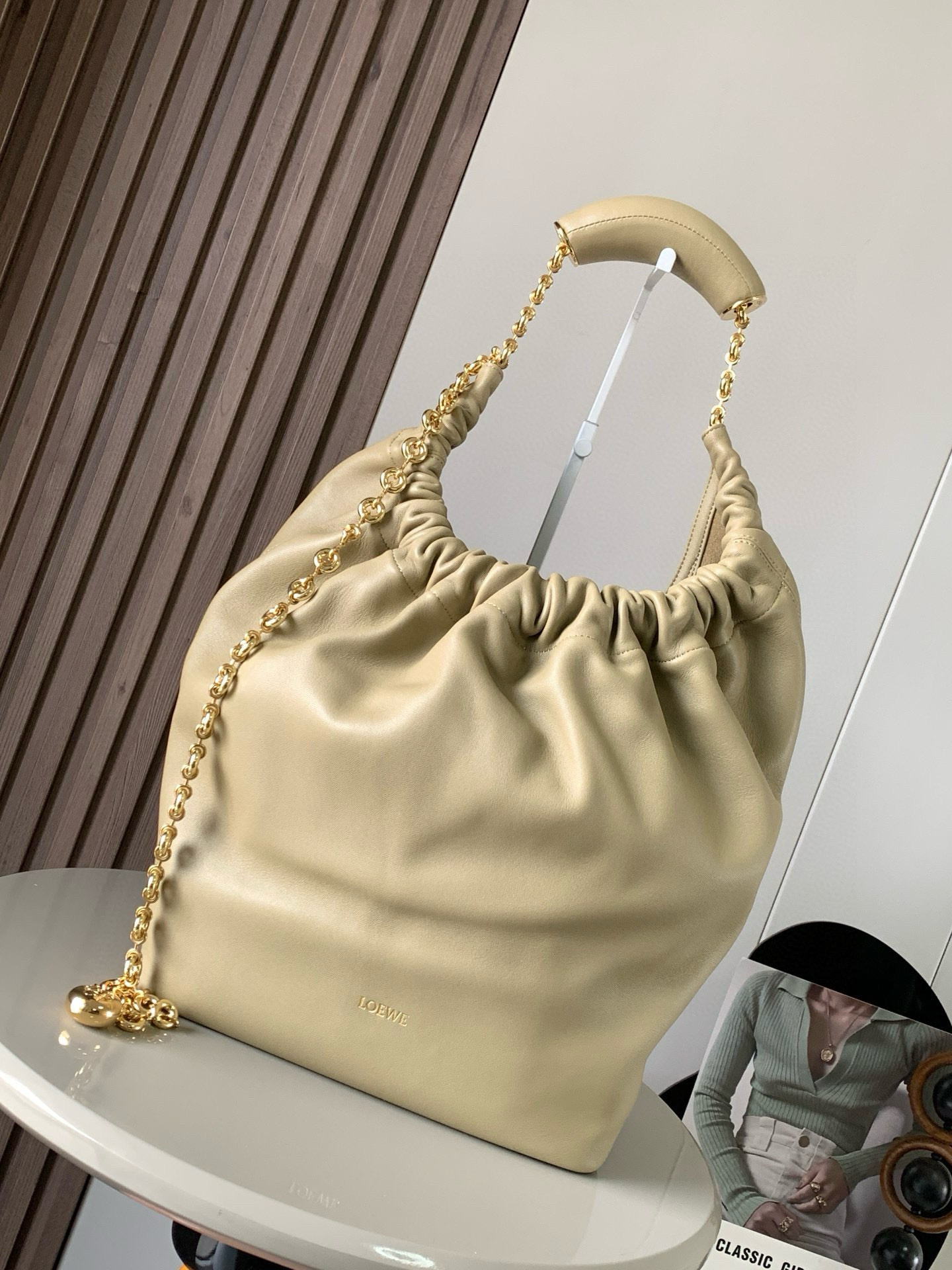 NO:209310,【Same Model for Celebrity】The medium-sized Napa Sheep Leather Squeeze handbag is a new exquisite and soft handbag. The newly released Squeeze handbag is made of soft and silky Mellow Napa Lambskin, which effectively reduces the weight of the bag. It is also lighter. The meniscus shaped bag has an elegant ruffle closing, creating a relaxed and casual attitude. Another highlight of this bag is that the ergonomic Squeeze airbag handle is matched with exquisite donut chains made of brass. The length can be adjusted by chain rings or extended chains can be added, so that the airbag handles such as handcarrying, shoulders, crossbody, etc. can slide freely to improve comfort. The bottom of the chain is decorated with an Anagram Pebble pendant, adding agile details to the bag. Size 34CM~33CM~13.5CM  Model number 9041 Color clay green, Loewe, sheepskin19860909【明星同款】中号纳帕羊皮革Squeeze手袋是款精致而柔美的全新手袋全新发布的 Squeeze 手袋采用柔软丝滑的Mellow纳帕小羊皮制作而成无衬里结构有效减轻包身自重观感上也更为轻盈弯月形包口以优雅的褶边收口,营造出轻松又随性的态度这款包包还有一大亮点是符合人体工程学的 Squeeze 气囊手柄搭配黄铜打造的精美甜甜圈链条可通过链环调节长短或添加延长链,实现手拎、肩背、斜挎等不同背法气囊手柄可自由滑动位置以提升舒适度链条底部点缀一枚 Anagram Pebble 吊坠,为包包增添灵动细节 尺寸34CM～33CM～13.5CM 款号9041 颜色黏土绿,罗意威,loewe,sheepskin,Bag