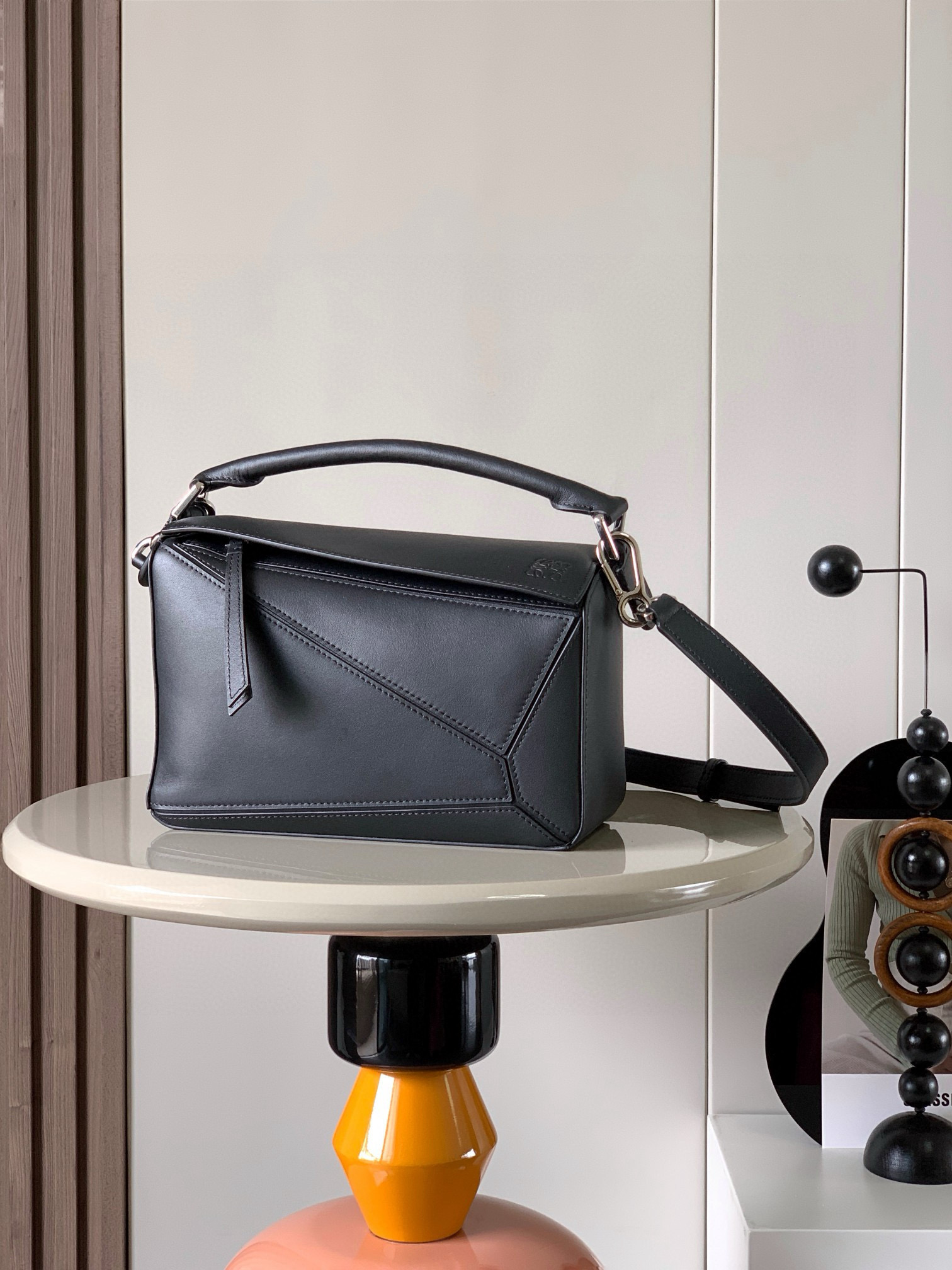 NO:384009,Geometric bag 24CMPuzzle handbags imported from original calfskin plains. Luojia’s popular geometric bag Puzzle handbag is the first handbag for L0EWE, the first handbag for the rectangular shape and precise cutting technology. Puzzle’s unique geometric lines. This small-size version is made of soft grain cowhide leather. Small Puzzle can accommodate for example a large wallet, mobile phones of all sizes and sunglasses with oblique, shoulders, hand holds or top handles. Removable size 24CM~16CM~10CM Model number 9005 Color black plainpattern, Loewe, loewe, wallets, cowhide19860909几何包24CMPuzzle手袋原厂进口小牛皮平纹 罗家爆款几何包Puzzle 手袋是创意总监乔纳森·安德森（ Jonathan Anderson）为 L0EWE 推出的首款手提包长方体形状和精确的切割技术创造了 Puzzle 独特的几何线条这个小尺寸版本采用柔软粒面牛皮革制成＊小号 Puzzle 可以容纳例如一只大号钱包、所有尺寸的手机和太阳镜斜、肩背、手拿或顶部提手携带＊可拆卸 尺寸24CM～16CM～10CM 款号9005 颜色黑色平纹,罗意威,loewe,loewe,wallets,cowhide,Bag