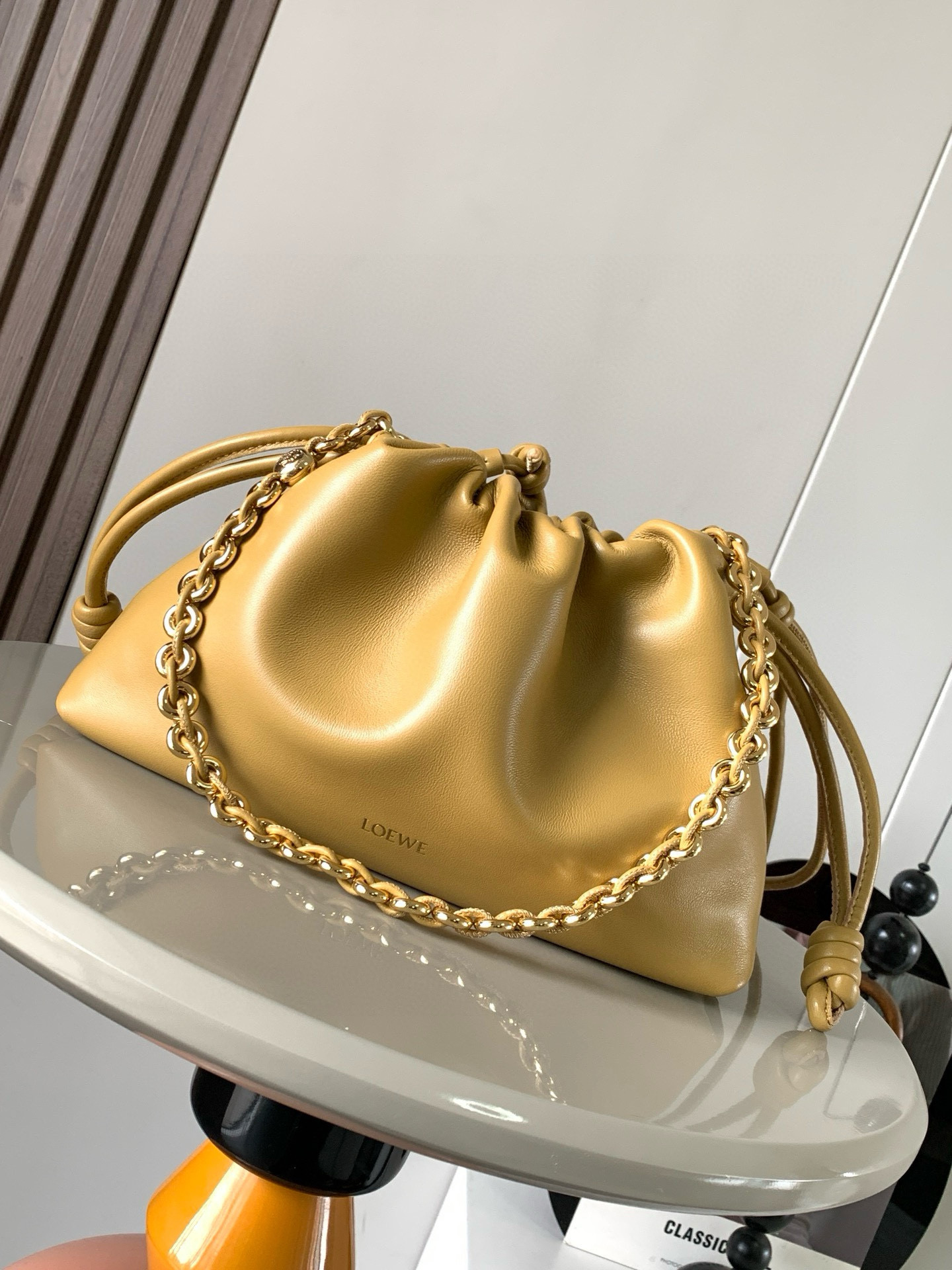 NO:384785,【Same Model for Celebrity】Soft Napa Sheep Leather Flamenco Purse New Clutch Flamenco Purse Handbags are wrinkled design on the sides with iconic knots and other key details. The style is fashionable and versatile and can be carried as a clutch or paired with a donut chain shoulder or leather shoulder strap crossbody. This version is made of soft Napa Sheep Leather. *Shoulder back, crossbody or hand-held *Removable adjustable leather shoulder strap *Removable donut chain embellished with Anagram engraved pebble *low-key magnetic buckle closure *Suede lining *LOEWE gold stamping or silver stamping model number 9057 Size 30cm ~ 20cm ~ 10.5cm Color Desert yellow, Loewe, loewe, handbag, sheepskin19860909【明星同款】柔软纳帕羊皮革 Flamenco Purse 新款手拿包Flamenco Purse 手袋采用褶皱设计侧面搭配标志性绳结等关键细节.款式时尚百搭可作为手拿包携带亦可搭配甜甜圈链条肩背或搭配皮革肩带斜挎.此版本采用柔软纳帕羊皮革制成.＊可肩背、斜挎或手提＊可拆卸可调节皮革肩带＊可拆卸甜甜圈链条饰有 Anagram 镌刻卵石纹＊低调的磁扣开合＊绒面革衬里＊ LOEWE 烫金或烫银 款号9057 尺寸30cm～20cm～10.5cm 颜色沙漠黄,罗意威,loewe,loewe,handbag,sheepskin,Bag