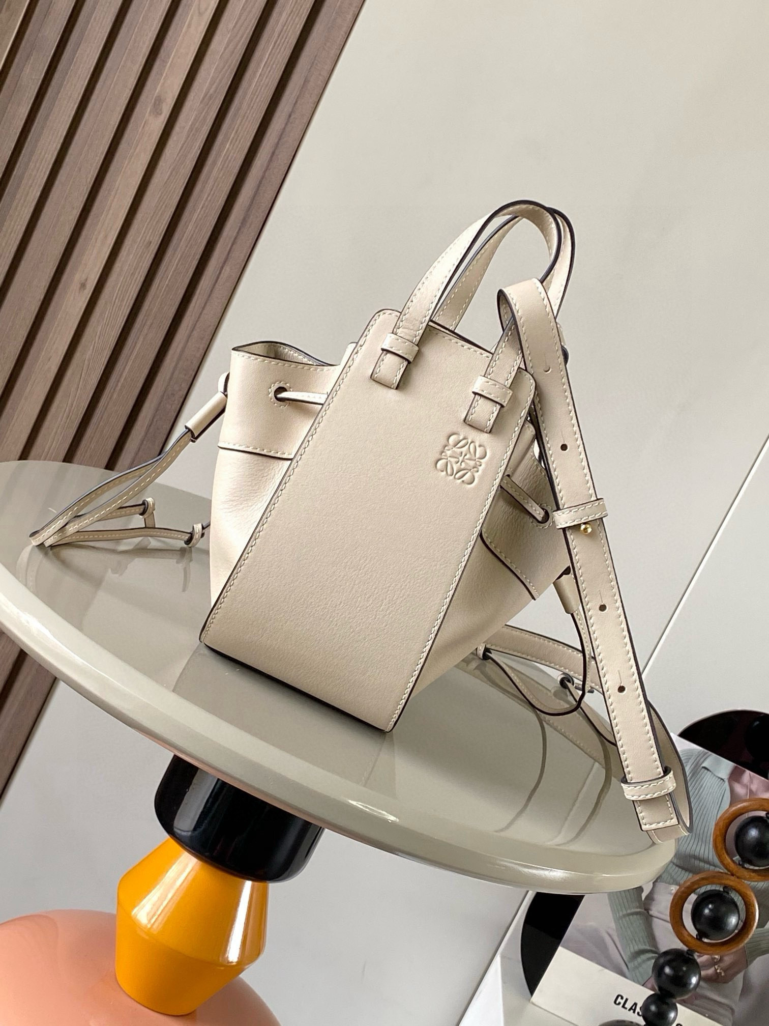 NO:385269,Mini Soft Grain Cowhide Leather Hammock Drawstring Bag with a soft side drawstring body can release the side drawstring to change shape. The loop strap can make the handbag have a variety of ways to wear this mini version is made of soft grain cowhide Leather. * Mini Hammock can hold for example a small vertical wallet, most sized phones (maximum 6.1 inches) and sunglasses case * Crossbody, shoulder or through top handle * Removable adjustable shoulder straps * Two internal insert bags * Can be customized with shoulder straps and personalized hangings * Herringbone cotton canvas lining * Anagram embossed Size 11cm~17cm~19.5cm Model No. 9069 Color apricot white plain, Loewe, wallets, cowhide19860909迷你柔软粒面牛皮革 Hammock 抽绳袋带有柔软侧面抽绳包身的多功能手袋可释放侧面抽绳来改变形状.环状带子可以使手袋有多种佩戴方式这个迷你版本采用柔软粒面牛皮革制成.＊迷你 Hammock可以容纳例如一只小号垂直钱包、大多数尺寸的手机（最大6.1英寸）和太阳镜盒＊斜挎,肩背或通过顶部提手携带＊可拆卸可调节肩带＊两个内部插袋＊可以使用肩带和个性化挂饰进行定制＊人字纹棉帆布衬里＊ Anagram 压纹 尺寸11cm～17cm～19.5cm 款号9069 颜色杏白平纹,罗意威,loewe,wallets,cowhide,Bag