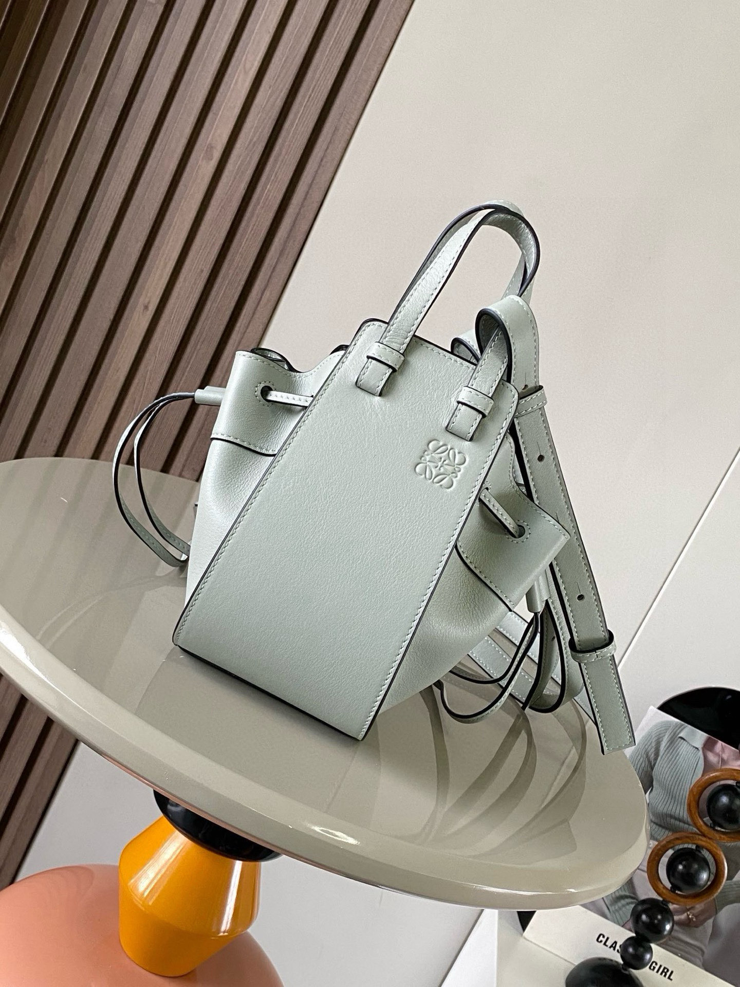 NO:385289,Mini Soft Grain Cowhide Leather Hammock Drawstring Bag with a soft side drawstring body can release the side drawstring to change shape. The looped strap can make the handbag have a variety of ways to wear this mini version is made of soft grained cowhide Leather. * Mini Hammock can hold for example a small vertical wallet, most sized phones (maximum 6.1 inches) and sunglasses case * Crossbody, shoulder or through top handle * Removable adjustable shoulder straps * Two internal insert bags * Can be customized with shoulder straps and personalized hangings * Herringbone cotton canvas lining * Anagram embossed Size 11cm~17cm~19.5cm Model No. 9069 Color grey plain, Loewe, wallets, cowhide19860909迷你柔软粒面牛皮革 Hammock 抽绳袋带有柔软侧面抽绳包身的多功能手袋可释放侧面抽绳来改变形状.环状带子可以使手袋有多种佩戴方式这个迷你版本采用柔软粒面牛皮革制成.＊迷你 Hammock可以容纳例如一只小号垂直钱包、大多数尺寸的手机（最大6.1英寸）和太阳镜盒＊斜挎,肩背或通过顶部提手携带＊可拆卸可调节肩带＊两个内部插袋＊可以使用肩带和个性化挂饰进行定制＊人字纹棉帆布衬里＊ Anagram 压纹 尺寸11cm～17cm～19.5cm 款号9069 颜色灰色平纹,罗意威,loewe,wallets,cowhide,Bag