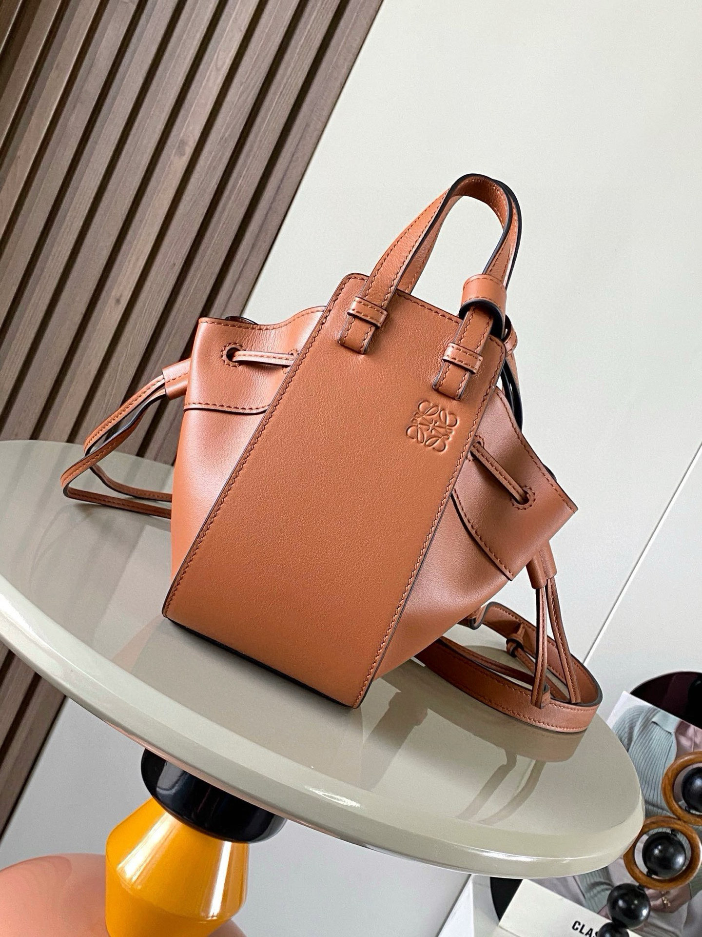 NO:385300,Mini Soft Grain Cowhide Leather Hammock Drawstring Bag with a soft side drawstring body can release the side drawstring to change shape. The looped strap can make the handbag have a variety of ways to wear this mini version is made of soft grained cowhide Leather. * Mini Hammock can hold for example a small vertical wallet, most sized phones (maximum 6.1 inches) and sunglasses case * Crossbody, shoulder or through top handle * Removable adjustable shoulder straps * Two internal insert bags * Can be customized with shoulder straps and personalized hangings * Herringbone cotton canvas lining * Anagram embossed Size 11cm~17cm~19.5cm Model No. 9069 Color brown plain, Loewe, wallets, cowhide19860909迷你柔软粒面牛皮革 Hammock 抽绳袋带有柔软侧面抽绳包身的多功能手袋可释放侧面抽绳来改变形状.环状带子可以使手袋有多种佩戴方式这个迷你版本采用柔软粒面牛皮革制成.＊迷你 Hammock可以容纳例如一只小号垂直钱包、大多数尺寸的手机（最大6.1英寸）和太阳镜盒＊斜挎,肩背或通过顶部提手携带＊可拆卸可调节肩带＊两个内部插袋＊可以使用肩带和个性化挂饰进行定制＊人字纹棉帆布衬里＊ Anagram 压纹 尺寸11cm～17cm～19.5cm 款号9069 颜色棕平纹,罗意威,loewe,wallets,cowhide,Bag