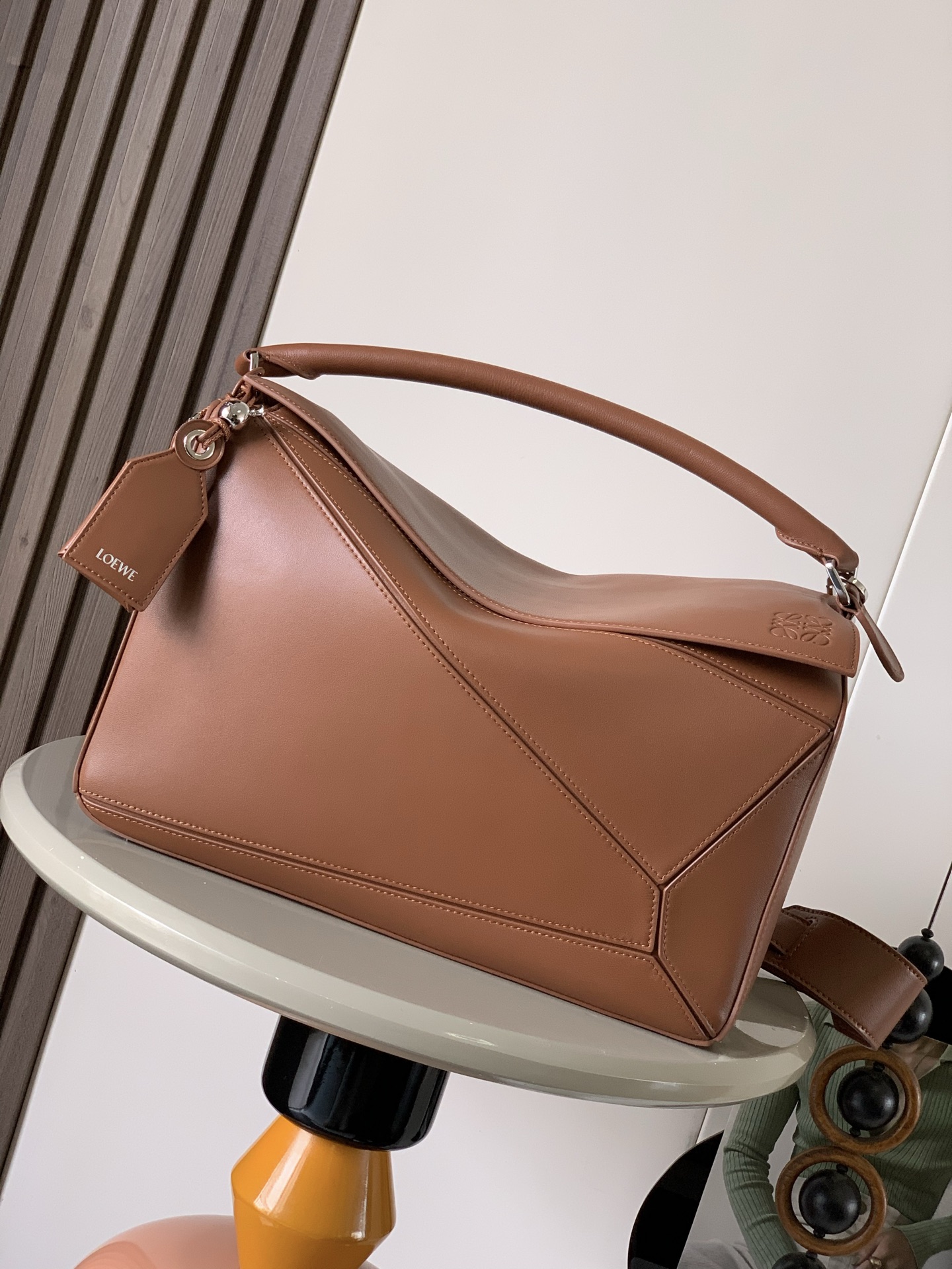 NO:391222,Large Napa Sheepskin Featherlight Puzzle Handbag Featherlight Puzzle With unique geometric lines, the rectangular shape is soft and lightweight Napa leather. The handbag is injected with casual and lazy style. The shoulder can be shoulder-mounted, cross-body or portable. The removable adjustable shoulder strap is decorated with rotary snaps. The zipper-closed articulated zipper head. One external zipper rear pocket. Two internal insert pockets. The decorative label is decorated with hidden pockets and balloon dice. 'Rectangular metal foot nails' Napa Sheepskin lining. *Anagram embossed, decorative internal engraved lettering. Size 33CM~21.5CM~17.5CM. Model No. 9099. Color brown, Loewe, sheepskin19860909大号纳帕羊皮革 Featherlight Puzzle 手袋Featherlight Puzzle 以别具一格的几何线条勾勒长方体造型柔软轻盈的纳帕皮革为手袋注入随性慵懒的风格*可肩背、斜挎或手提*可拆卸可调节肩带饰有旋转卡扣*拉链开合铰接式拉链头*一个外部拉链后袋两个内部插袋*可拆卸烫金或烫银标签饰有隐秘口袋和气球骰子“长方形金属脚钉“纳帕羊皮革衬里 *Anagram 压纹、饰牌内部镌刻字样 尺寸33CM～21.5CM～17.5CM 款号9099 颜色棕色,罗意威,loewe,sheepskin,Bag