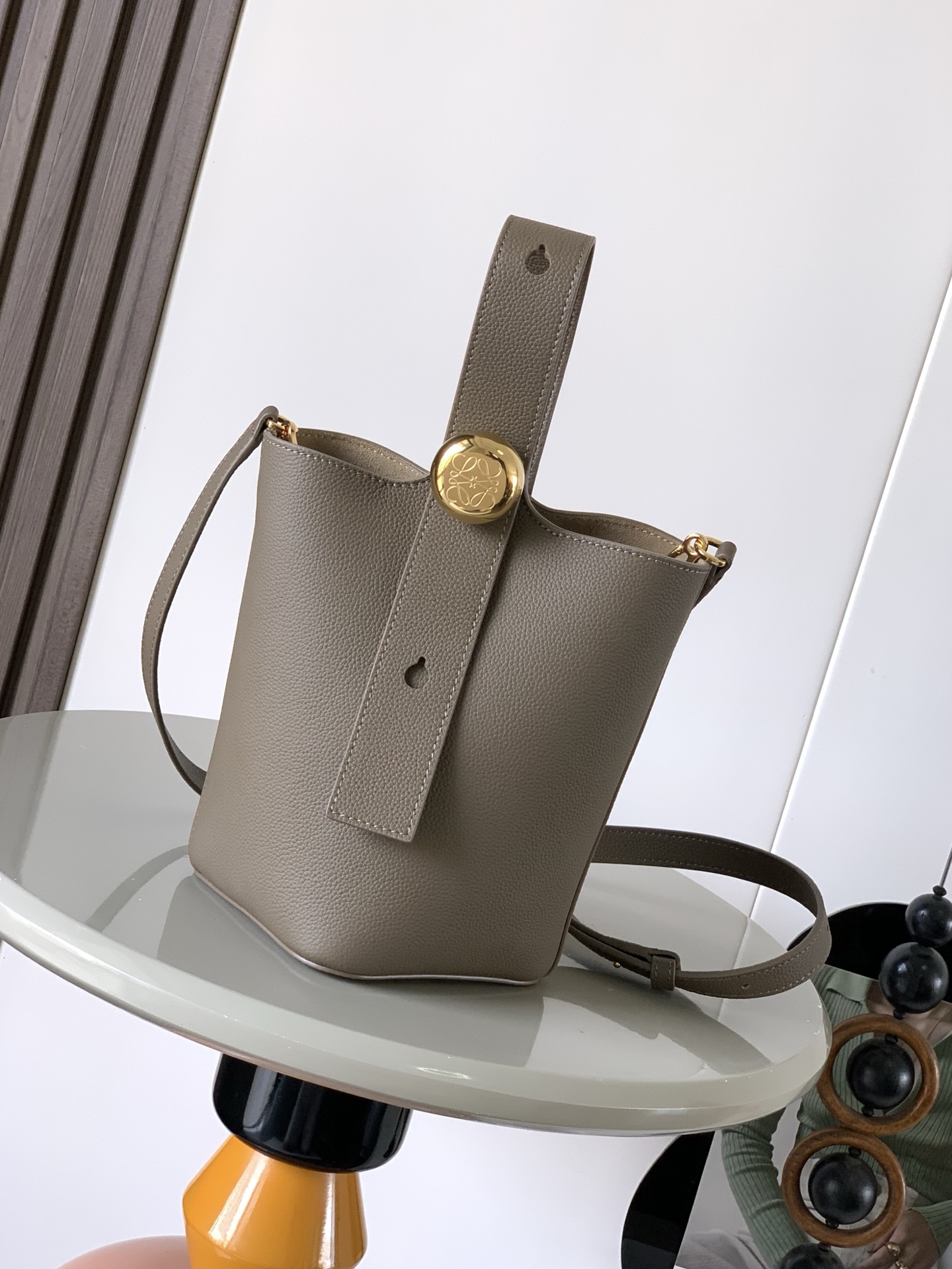 NO:391243,Mini Soft Grain Cowhide Leather Pebble Bucket Handbag Pebble cleverly combines pure simple lines with eye-catching design style to create a unique and innovative handbag design. The iconic Anagram engraving hardware combines decorative and practical functions, adjusts the length of the shoulder strap and is suitable for a variety of carrying methods. The unique twisted structure complements the delicate details. This mini version is made of soft grain cowhide. It can be cross-body, shoulder or hand-held * Adjustable removable shoulder strap * Magnetic buckle closure * Inner bag * Synthetic leather lining * Anagram engraving pebble Model number 9047 Color Taupe Size 20CM~16CM~16CM, Loewe, cowhide19860909迷你柔软粒面牛皮革 Pebble Bucket 水桶手袋Pebble将纯粹的简约线条与瞩目设计风格巧妙融合造就别具一格的创新的手袋设计.标志性的 Anagram 雕刻五金件兼具装饰和实用功能,可调节肩带长度并适合多种携带方式,独特的扭曲结构与微妙的细节相得益彰.此迷你版本采用柔软粒面牛皮革制成.可斜挎、肩背或手提＊可调节可拆卸肩带＊磁扣开合＊内袋＊合成革衬里* Anagram 雕刻卵石 款号9047 颜色灰褐色荔 尺寸20CM～16CM～16CM,罗意威,loewe,cowhide,Bag