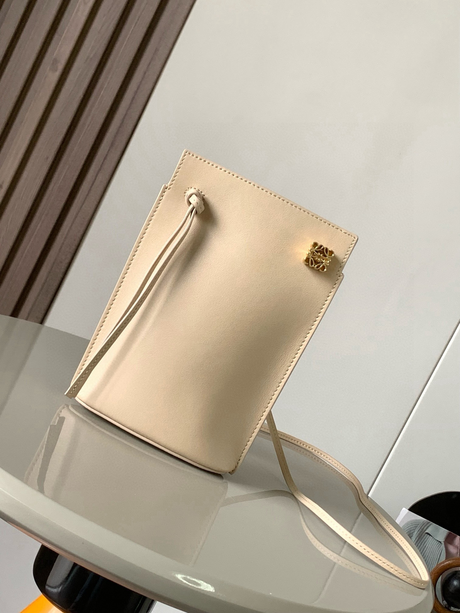 NO:394890,Dice pocket cowhide dice mobile phone bag imported from the original Napa calf leather practical bag is equipped with shoulder straps and Anagram three-dimensional logo. It can be shoulder-mounted or cross-body, with two leather straps. It can be added with personalized dice decoration. The base is embossed with L0EWE steel stamp. The overall simple and generous leather is hard and not easy to deform. The top layer of cowhide is delicate and shiny. The whole bag is made of full-head layer of cowhide material, with a sturdy three-dimensional gold metal logo. The decoration is low-key and luxurious. The capacity inside is quite large. It can be equipped with a large screen mobile phone with a large screen, lipstick. Size 20.5~13~4.5CM. Model number 9027. Ivory, Loewe, loewe, cowhide.19860909dice pocket牛皮骰子手机包原厂进口纳帕小牛皮实用小包配有肩带和Anagram立体Logo可肩背或斜挎,带有两条皮革带子,可添加个性化骰子装饰串珠底座上带有L0EWE钢印压纹,整体简约大方皮质是偏硬的,不容易变形,头层牛皮,皮质细腻有光泽,整个包包都是全头层牛皮材质包身硬挺有型立体金色金属logo装饰低调奢华,里面的容量还挺大的,可以装大屏手机的大屏手机,口红 尺寸20.5～13～4.5CM 款号9027 颜色象牙色,罗意威,loewe,cowhide,Bag