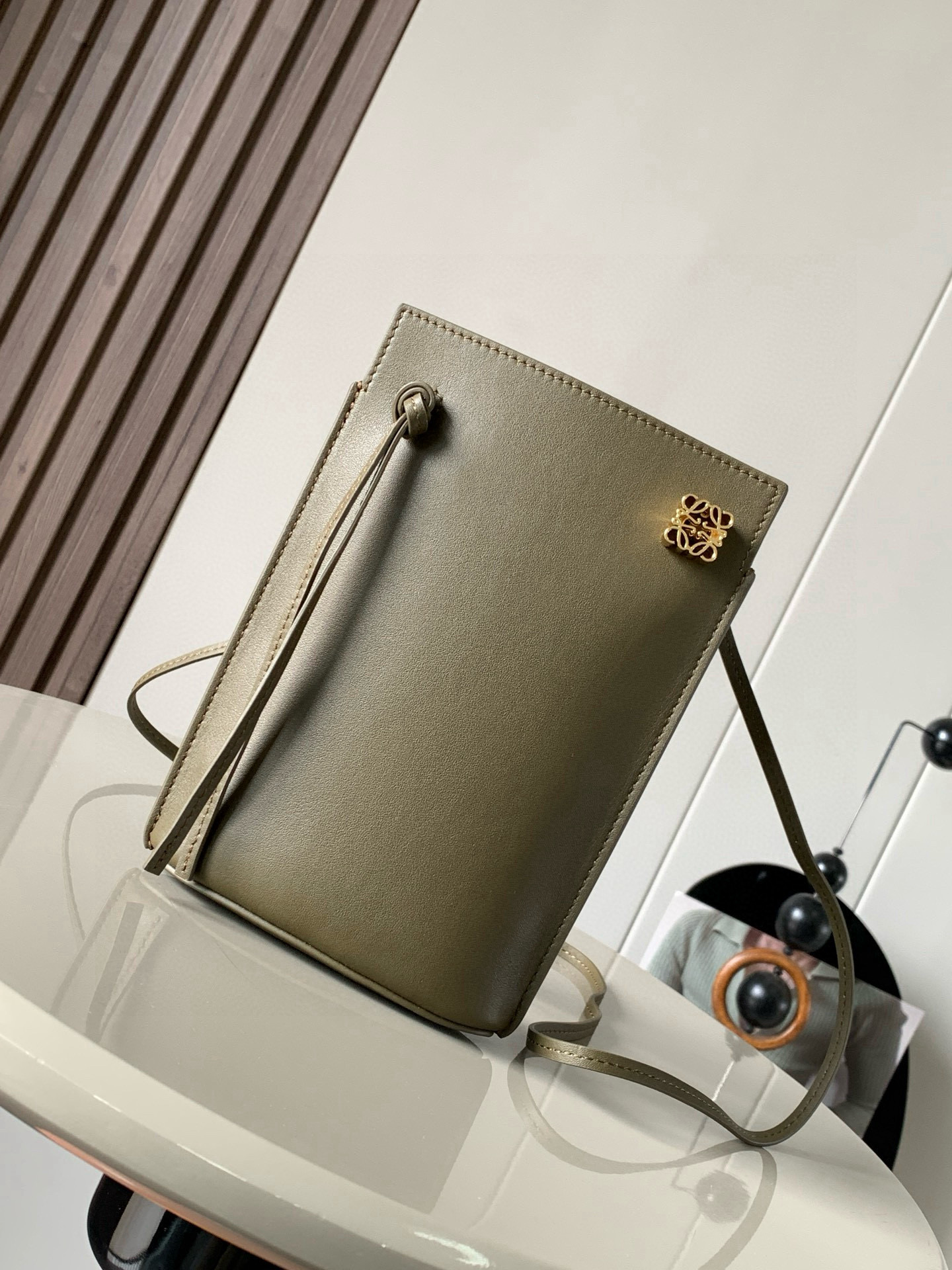 NO:394902,Dice pocket cowhide dice mobile phone bag imported from the original Napa calf leather practical bag is equipped with shoulder straps and Anagram three-dimensional logo. It can be shoulder-mounted or cross-body, with two leather straps. It can be added with personalized dice decoration. The base is embossed with L0EWE steel stamp. The overall simple and generous leather is hard and not easy to deform. The top layer of cowhide is delicate and shiny. The whole bag is made of full-head layer of cowhide material, with a sturdy three-dimensional gold metal logo. The decoration is low-key and luxurious. The capacity inside is quite large. It can be equipped with a large screen mobile phone with a large screen, lipstick. Size 20.5~13~4.5CM. Model number 9027. Color is dark khaki green, Luo Yiwei, loewe, cowhide.19860909dice pocket牛皮骰子手机包原厂进口纳帕小牛皮实用小包配有肩带和Anagram立体Logo可肩背或斜挎,带有两条皮革带子,可添加个性化骰子装饰串珠底座上带有L0EWE钢印压纹,整体简约大方皮质是偏硬的,不容易变形,头层牛皮,皮质细腻有光泽,整个包包都是全头层牛皮材质包身硬挺有型立体金色金属logo装饰低调奢华,里面的容量还挺大的,可以装大屏手机的大屏手机,口红 尺寸20.5～13～4.5CM 款号9027 颜色深卡其绿,罗意威,loewe,cowhide,Bag