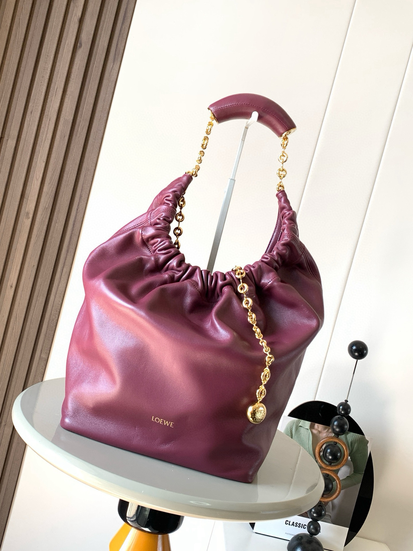 NO:395345,【Same Model for Celebrity】The medium-sized Napa Sheep Leather Squeeze handbag is a new exquisite and soft handbag. The newly released Squeeze handbag is made of soft and silky Mellow Napa Lambskin, which effectively reduces the weight of the bag. It is also lighter. The meniscus shaped bag has an elegant ruffle closing, creating a relaxed and casual attitude. Another highlight of this bag is that the ergonomic Squeeze airbag handle is matched with exquisite donut chains made of brass. The length can be adjusted by chain rings or extended chains can be added, so that the airbag handles such as handcarrying, shoulders, crossbody, etc. can slide freely to improve comfort. The bottom of the chain is decorated with an Anagram Pebble pendant, adding agile details to the bag. Size 34CM~33CM~13.5CM  Model number 9041 Crimson color, Loewe, sheepskin19860909【明星同款】中号纳帕羊皮革Squeeze手袋是款精致而柔美的全新手袋全新发布的 Squeeze 手袋采用柔软丝滑的Mellow纳帕小羊皮制作而成无衬里结构有效减轻包身自重观感上也更为轻盈弯月形包口以优雅的褶边收口,营造出轻松又随性的态度这款包包还有一大亮点是符合人体工程学的 Squeeze 气囊手柄搭配黄铜打造的精美甜甜圈链条可通过链环调节长短或添加延长链,实现手拎、肩背、斜挎等不同背法气囊手柄可自由滑动位置以提升舒适度链条底部点缀一枚Anagram Pebble 吊坠,为包包增添灵动细节 尺寸34CM～33CM～13.5CM 款号9041 颜色绯红,罗意威,loewe,sheepskin,Bag