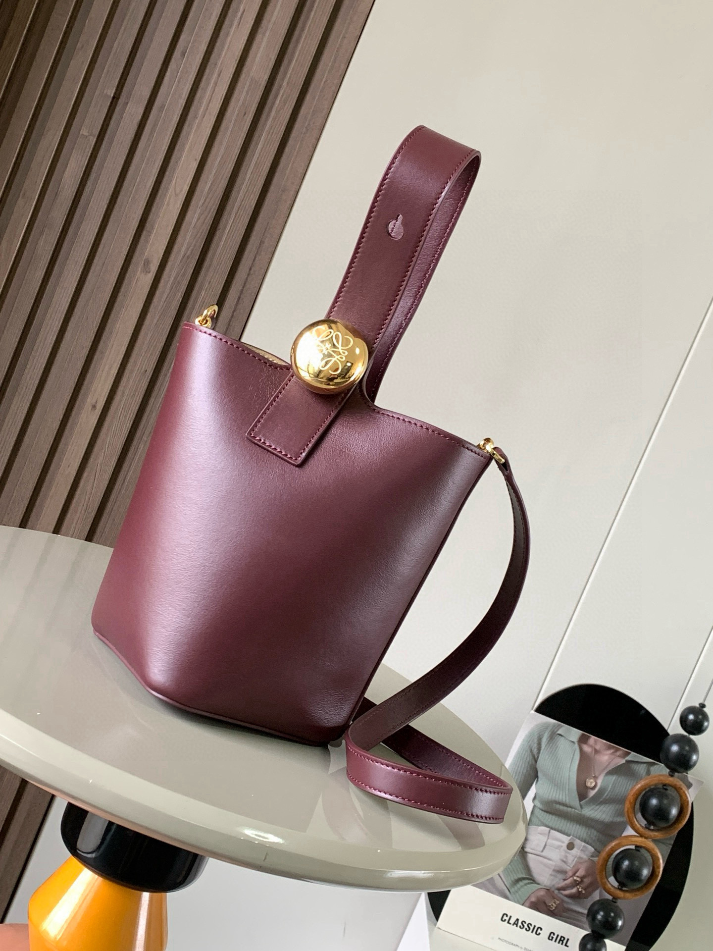 NO:395379,Mini Soft Grain Cowhide Leather Pebble Bucket Handbag Pebble cleverly combines pure simple lines with eye-catching design style to create a unique and innovative handbag design. The iconic Anagram engraving hardware combines decorative and practical functions, adjusts the length of the shoulder strap and is suitable for a variety of carrying methods. The unique twisted structure complements the delicate details. This mini version is made of soft grain cowhide. It can be cross-body, shoulder or hand-held * Adjustable removable shoulder strap * Magnetic buckle closure * Inner bag * Synthetic leather lining * Anagram engraving pebble Model number 9047 Color burgundy plain size 20CM~16CM~16CM, Loewe, cowhide19860909迷你柔软粒面牛皮革 Pebble Bucket 水桶手袋Pebble将纯粹的简约线条与瞩目设计风格巧妙融合造就别具一格的创新的手袋设计.标志性的 Anagram 雕刻五金件兼具装饰和实用功能,可调节肩带长度并适合多种携带方式,独特的扭曲结构与微妙的细节相得益彰.此迷你版本采用柔软粒面牛皮革制成.可斜挎、肩背或手提＊可调节可拆卸肩带＊磁扣开合＊内袋＊合成革衬里* Anagram 雕刻卵石 款号9047 颜色酒红平纹 尺寸20CM～16CM～16CM,罗意威,loewe,cowhide,Bag