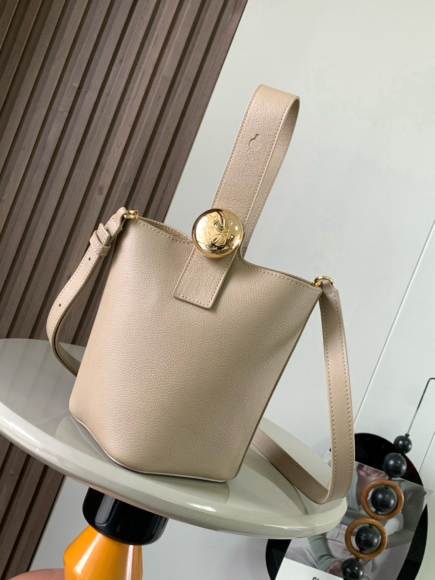NO:395381,Mini Soft Grain Cowhide Leather Pebble Bucket Handbag Pebble cleverly combines pure simple lines with eye-catching design style to create a unique and innovative handbag design. The iconic Anagram engraving hardware combines decorative and practical functions, adjusts the length of the shoulder strap and is suitable for a variety of carrying methods. The unique twisted structure complements the delicate details. This mini version is made of soft grain cowhide. It can be cross-body, shoulder or hand-held * Adjustable removable shoulder strap * Magnetic buckle closure * Inner bag * Synthetic leather lining * Anagram engraving pebble Model No. 9047 Color sand color lychee pattern Size 20CM~16CM~16CM, Loewe, cowhide19860909迷你柔软粒面牛皮革 Pebble Bucket 水桶手袋Pebble将纯粹的简约线条与瞩目设计风格巧妙融合造就别具一格的创新的手袋设计.标志性的 Anagram 雕刻五金件兼具装饰和实用功能,可调节肩带长度并适合多种携带方式,独特的扭曲结构与微妙的细节相得益彰.此迷你版本采用柔软粒面牛皮革制成.可斜挎、肩背或手提＊可调节可拆卸肩带＊磁扣开合＊内袋＊合成革衬里* Anagram 雕刻卵石 款号9047 颜色沙色荔枝纹 尺寸20CM～16CM～16CM,罗意威,loewe,cowhide,Bag