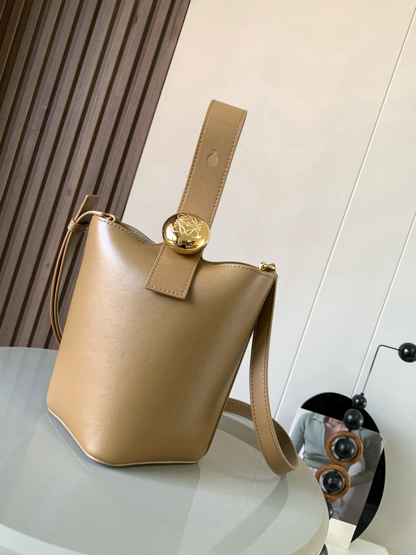 NO:395372,Mini Soft Grain Cowhide Leather Pebble Bucket Handbag Pebble cleverly combines pure simple lines with eye-catching design style to create a unique and innovative handbag design. The iconic Anagram engraving hardware combines decorative and practical functions, adjusts the length of the shoulder strap and is suitable for a variety of carrying methods. The unique twisted structure complements the delicate details. This mini version is made of soft grain cowhide. It can be cross-body, shoulder or hand-held * Adjustable removable shoulder strap * Magnetic buckle closure * Inner bag * Synthetic leather lining * Anagram engraving pebble Model number 9047 Color oak brown Size 20CM~16CM~16CM, Loewe, cowhide19860909迷你柔软粒面牛皮革 Pebble Bucket 水桶手袋Pebble将纯粹的简约线条与瞩目设计风格巧妙融合造就别具一格的创新的手袋设计.标志性的 Anagram 雕刻五金件兼具装饰和实用功能,可调节肩带长度并适合多种携带方式,独特的扭曲结构与微妙的细节相得益彰.此迷你版本采用柔软粒面牛皮革制成.可斜挎、肩背或手提＊可调节可拆卸肩带＊磁扣开合＊内袋＊合成革衬里* Anagram 雕刻卵石 款号9047 颜色橡木棕 尺寸20CM～16CM～16CM,罗意威,loewe,cowhide,Bag