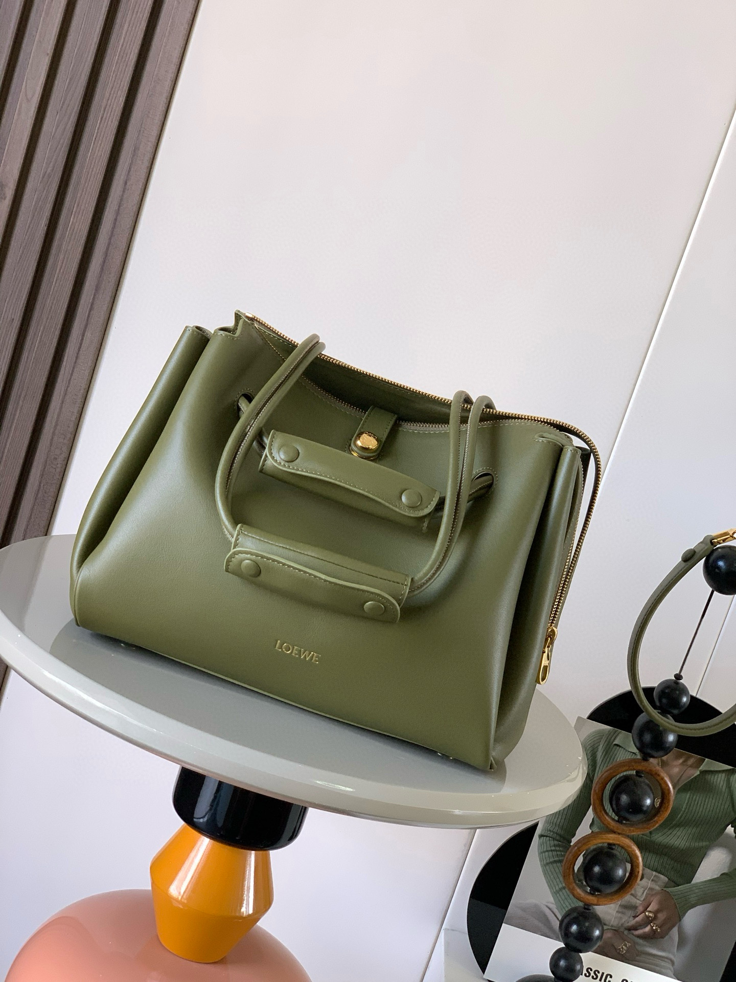 NO:406405,Medium soft cowhide leather Madrid handbags Madrid has a soft structure and a trapezoidal shape with an adjustable handle and a Pebble magnetic buckle This medium version is made of soft cowhide leather with a shoulder-back, crossbody or hand-held* adjustable shoulder straps, paired with leather extension straps *AnagramPebble magnetic buckle zipper closure*One zipper inner bag *Anagram Pebble metal foot nails*Napa sheepskin lining Size 28.5CM~23CM~11CM Model No. 9147 Color olive green, Loewe, cowhide, sheepskin19860909中号柔软牛皮革 Madrid手袋Madrid 具有柔软的结构感梯形造型采用角撑设计,搭配可调节提手和 Pebble 磁扣此中号版本采用柔软牛皮革制成*可肩背、斜挎或手提*可调节肩带,搭配皮革延长带 *AnagramPebble 磁扣开合拉链开合*一个拉链内袋 *Anagram Pebble金属脚钉*纳帕羊皮革衬里 尺寸28.5CM～23CM～11CM 款号9147 颜色橄榄绿,罗意威,loewe,cowhide,sheepskin,Bag