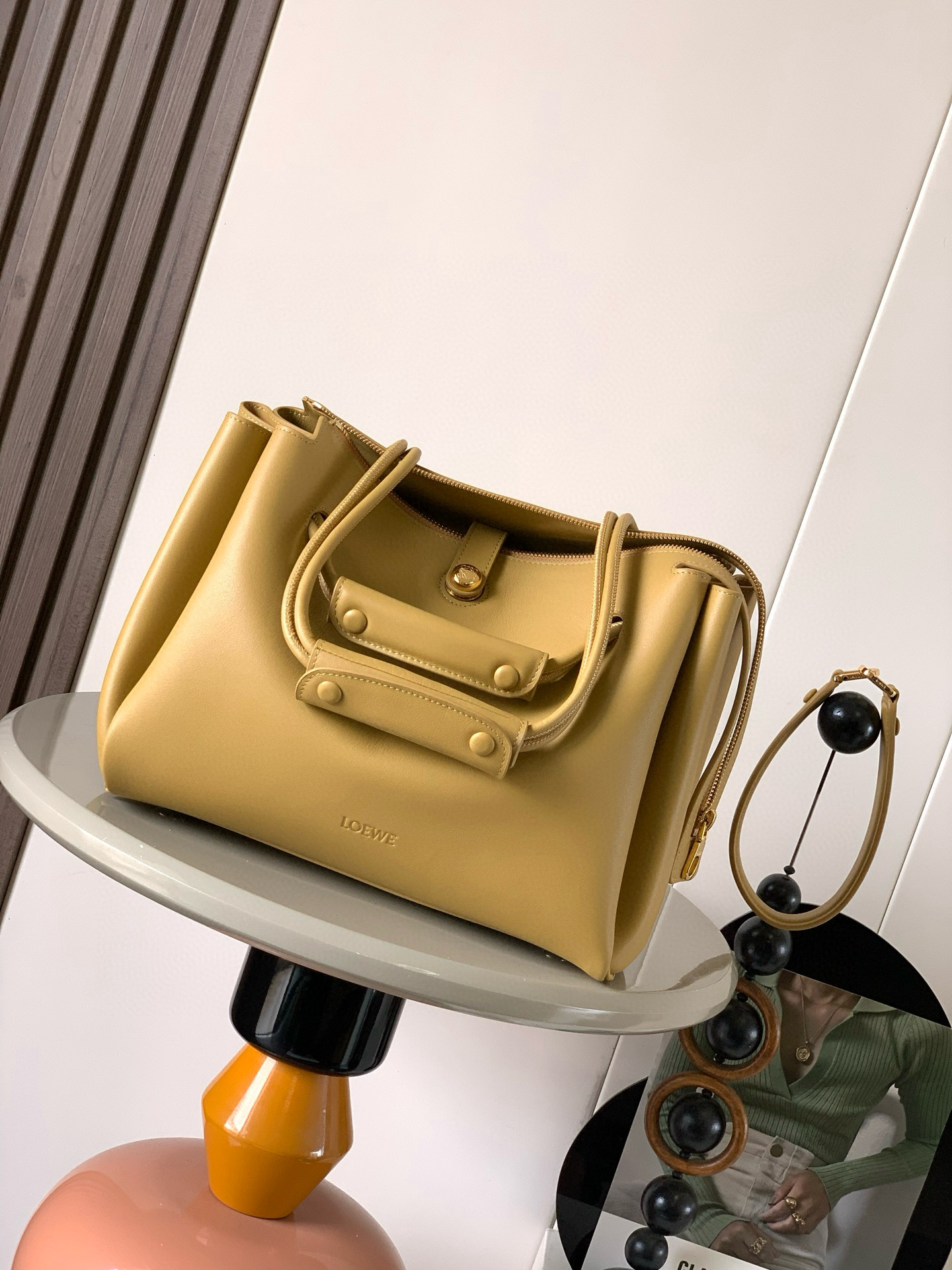 NO:406415,Medium soft cowhide leather Madrid handbags Madrid has a soft structure and a trapezoidal shape with an adjustable handle and a Pebble magnetic buckle This medium version is made of soft cowhide leather with a shoulder-back, crossbody or hand-held* adjustable shoulder straps, paired with leather extension straps *AnagramPebble magnetic buckle zipper closure *One zipper inner bag *Anagram Pebble metal foot nails *Napa sheepskin lining Size 28.5CM~23CM~11CM Model number 9147 Color warm sand yellow, Loewe, cowhide, sheepskin19860909中号柔软牛皮革 Madrid手袋Madrid 具有柔软的结构感梯形造型采用角撑设计,搭配可调节提手和 Pebble 磁扣此中号版本采用柔软牛皮革制成*可肩背、斜挎或手提*可调节肩带,搭配皮革延长带 *AnagramPebble 磁扣开合拉链开合*一个拉链内袋 *Anagram Pebble金属脚钉*纳帕羊皮革衬里 尺寸28.5CM～23CM～11CM 款号9147 颜色暖沙黄,罗意威,loewe,cowhide,sheepskin,Bag