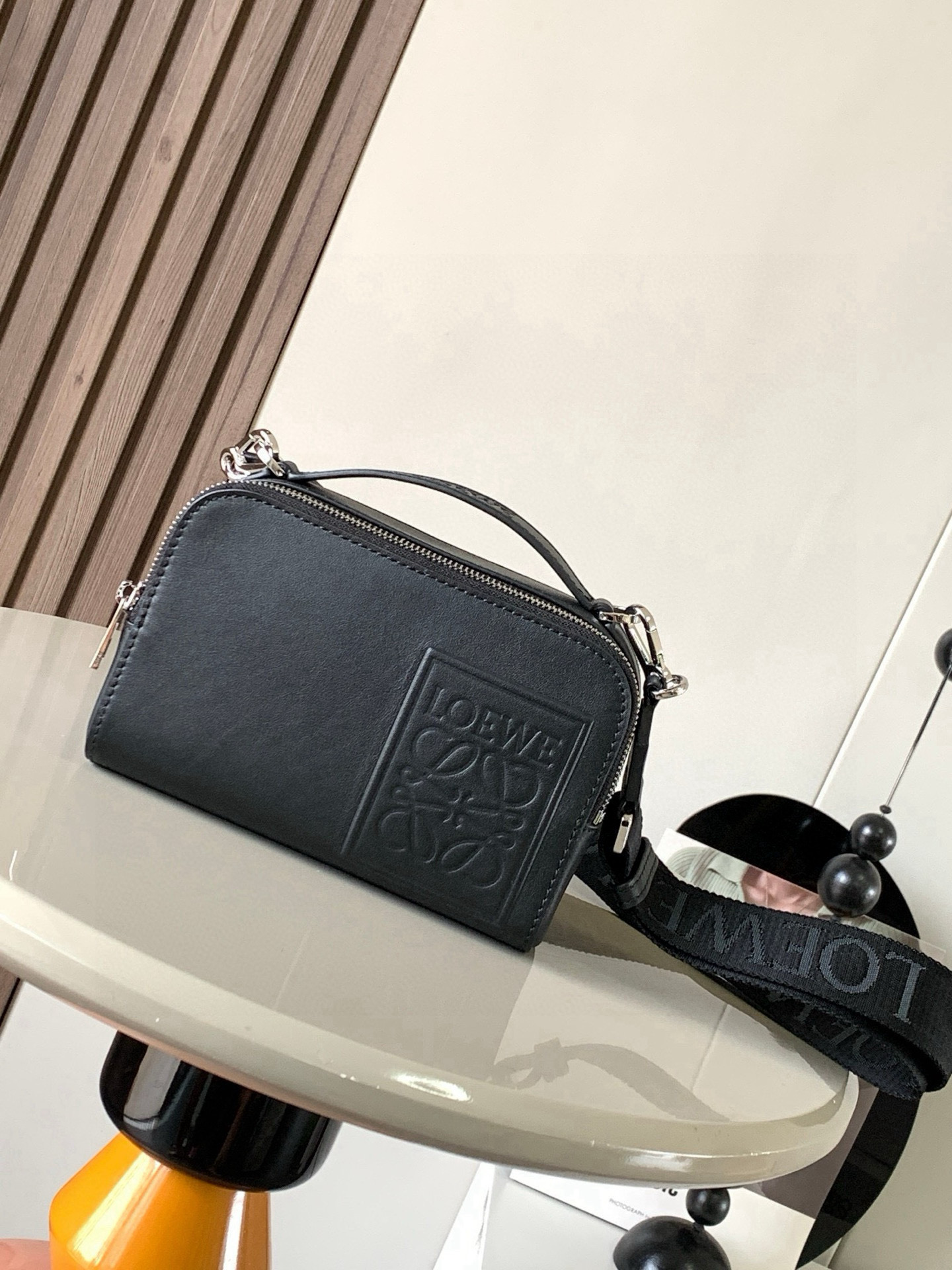 NO:406450,Satin cowhide leather mini camera crossbody bag meets your multifunctional needs. This mini camera bag is made of satin cowhide leather and is smooth in texture, showing the high-quality mini camera crossbody bag design is compact and practical, with two zipper compartments to facilitate storage of cameras and other small objects, whether for travel or daily use, and can meet your needs. At the same time, the removable shoulder strap and top handle design can allow you to choose a crossbody or carry method according to your needs. Flexible carrying is not only practical, but also a beautiful combination of personality and taste. Size 18CM~13CM~8.5CM  Model number 9111 color black plain paper, Loewe, satchels, crossbody bags, cowhide19860909缎面牛皮革迷你相机斜挎包 满足你的多功能需求,这款迷你相机包采用缎面牛皮革制成质感柔滑,展现出高级品质迷你相机斜挎包设计紧凑实用,设有两个拉链隔层,方便存放相机和其他小物件无论是旅行还是日常使用,都能满足你的需求同时,可调整可拆卸肩带和顶部提手设计,让你可以根据需要选择斜挎或手提方式,灵活携带除了实用性,这款相机包还注重细节.插袋设计方便存放小物件人字纹棉质帆布衬里保护相机免受刮擦.Anagram压纹贴片作为品牌标志,为相机包增添了一丝奢华感不仅是一款实用的摄影配件,更是一件时尚的潮流单品让它成为你的时尚标志,展现个性与品味的完美结合 尺寸18CM~13CM~8.5CM 款号9111 颜色黑色平纹,罗意威,loewe,satchels,crossbody bags,cowhide,Bag