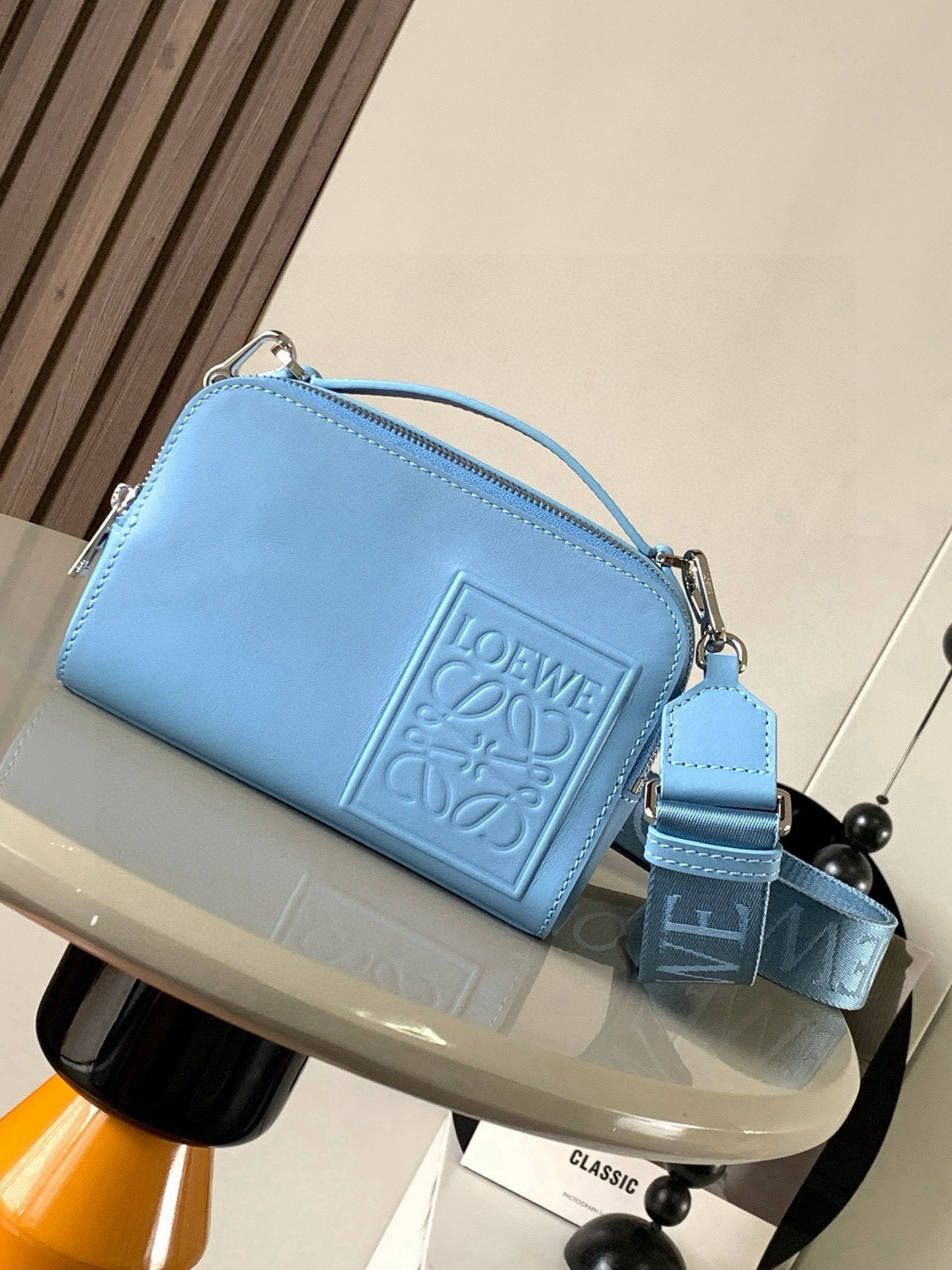 NO:406428,Satin cowhide leather mini camera crossbody bag meets your multifunctional needs. This mini camera bag is made of satin cowhide leather and is smooth in texture, showing the high-quality mini camera crossbody bag design is compact and practical, with two zipper compartments to facilitate storage of cameras and other small objects, whether for travel or daily use, and can meet your needs. At the same time, the removable shoulder strap and top handle design can allow you to choose a crossbody or carry method according to your needs. Flexible carrying is not only practical, but also a beautiful combination of personality and taste. Size 18CM~13CM~8.5CM  Model number 9111 Color blue, Loewe, scatchels, crossbody bags, cowhide19860909缎面牛皮革迷你相机斜挎包 满足你的多功能需求,这款迷你相机包采用缎面牛皮革制成质感柔滑,展现出高级品质迷你相机斜挎包设计紧凑实用,设有两个拉链隔层,方便存放相机和其他小物件无论是旅行还是日常使用,都能满足你的需求同时,可调整可拆卸肩带和顶部提手设计,让你可以根据需要选择斜挎或手提方式,灵活携带除了实用性,这款相机包还注重细节.插袋设计方便存放小物件人字纹棉质帆布衬里保护相机免受刮擦.Anagram压纹贴片作为品牌标志,为相机包增添了一丝奢华感不仅是一款实用的摄影配件,更是一件时尚的潮流单品让它成为你的时尚标志,展现个性与品味的完美结合 尺寸18CM~13CM~8.5CM 款号9111 颜色蓝色,罗意威,loewe,satchels,crossbody bags,cowhide,Bag